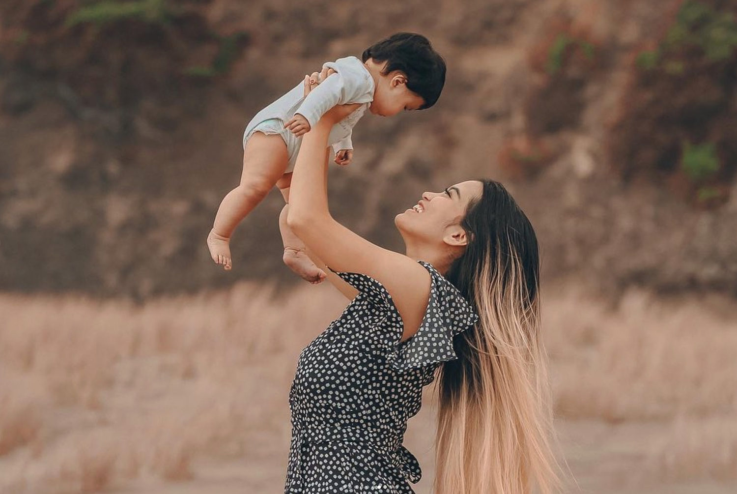 Cinematic portrait of a mother and child at Piha, New Zealand, with crashing waves and golden mist.