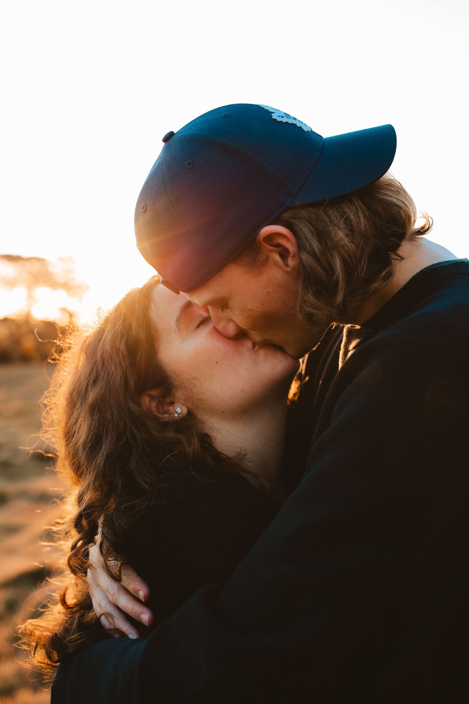 A man giving a woman a piggyback ride in a field, showing fun lifestyle photography inspiration.