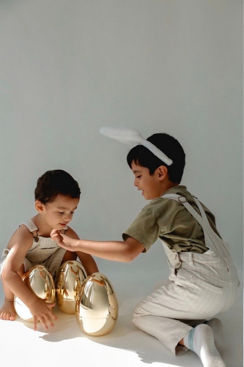 Candid photo of a child wearing bunny ears and laughing on a spring-themed studio set.