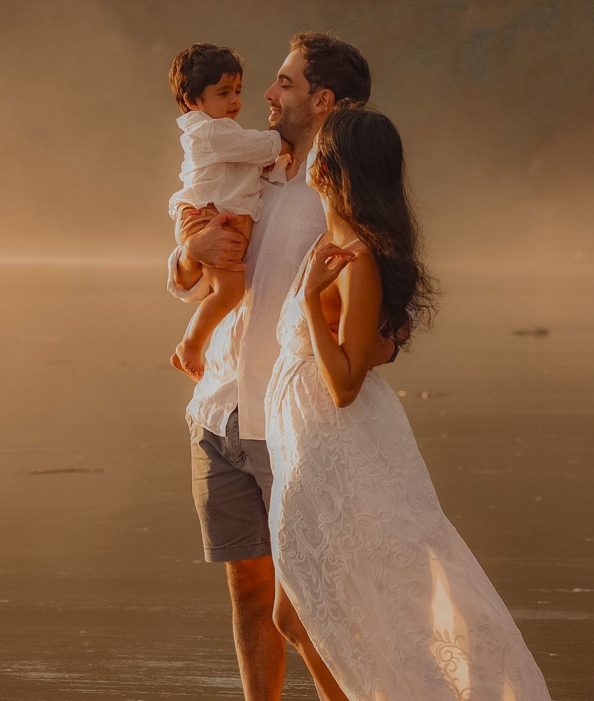 Maternity Photographer in Auckland. Soft warm tones, during golden light at Piha Beach at sunset.