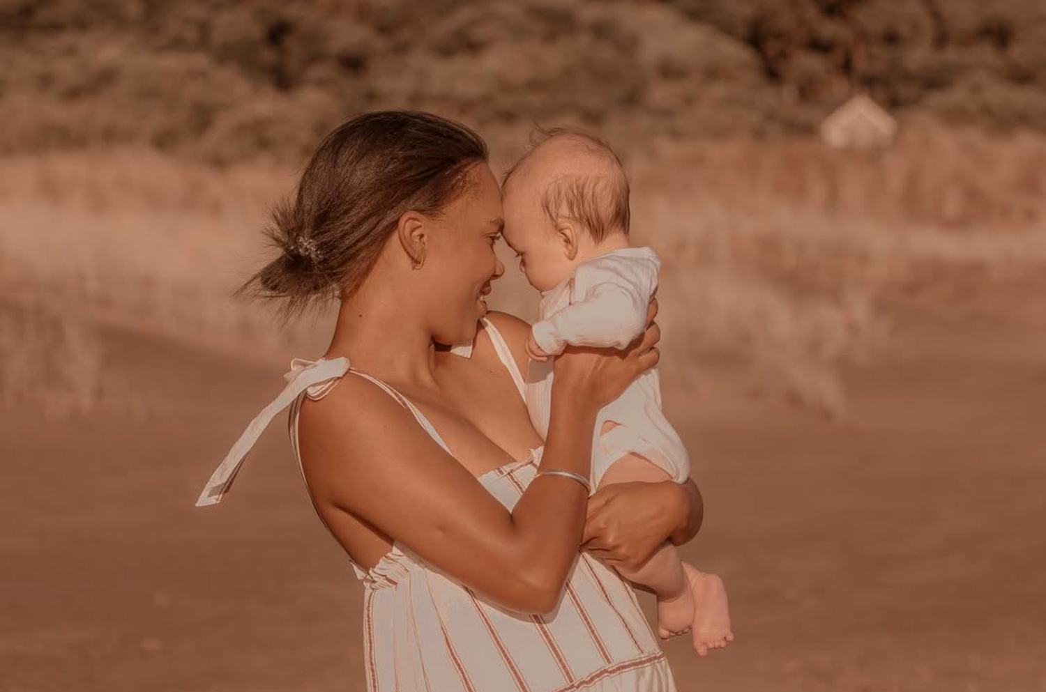 Maternity session at Piha Beach with Lion Rock in the background.