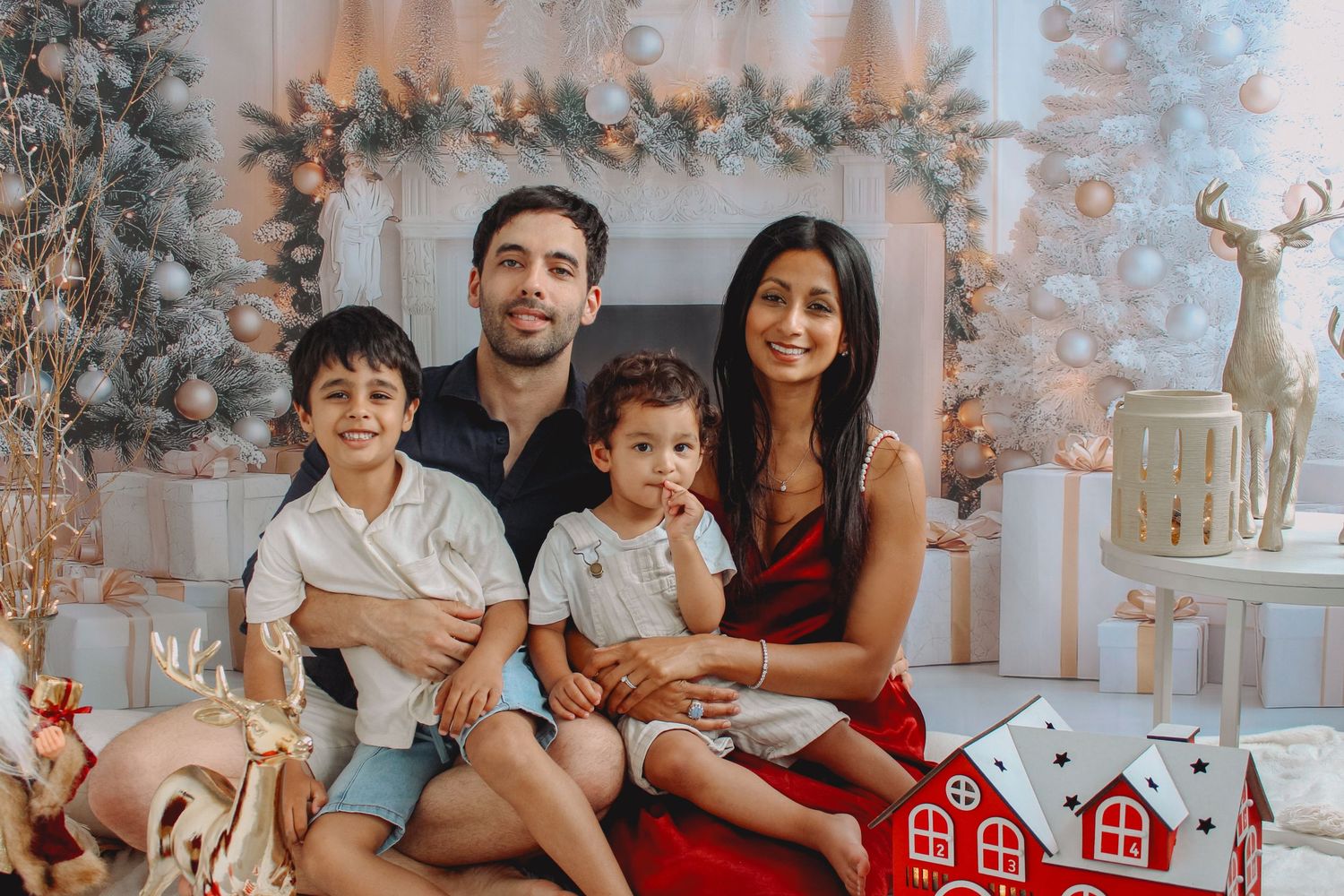 Family Christmas studio session in Auckland with neutral tones and a simple pine tree.