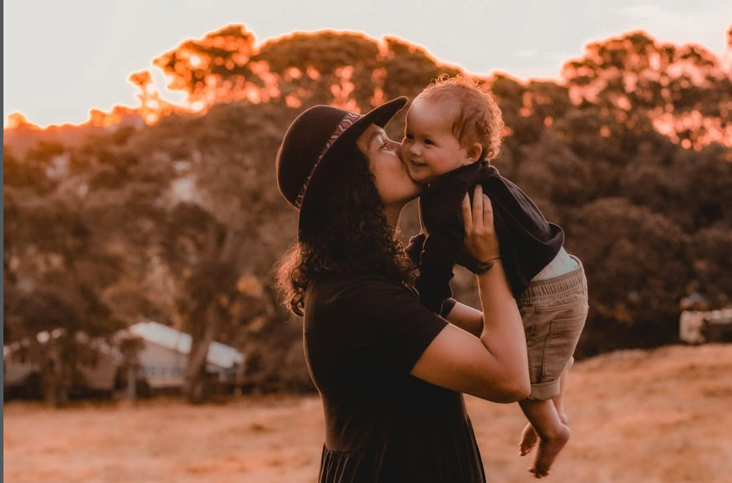 Candid family portrait under the large oak trees at Cornwall Park, Auckland, during a golden hour session.