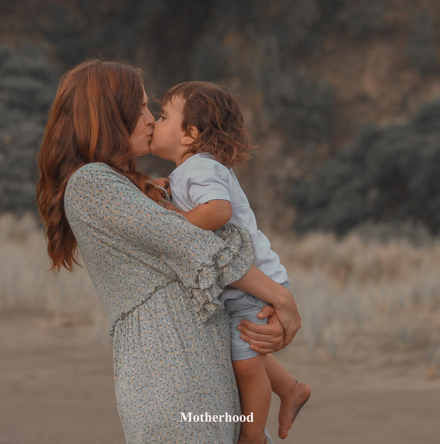 A heartwarming moment of a mother and son hugging during a family photography session in Auckland Piha Beach.