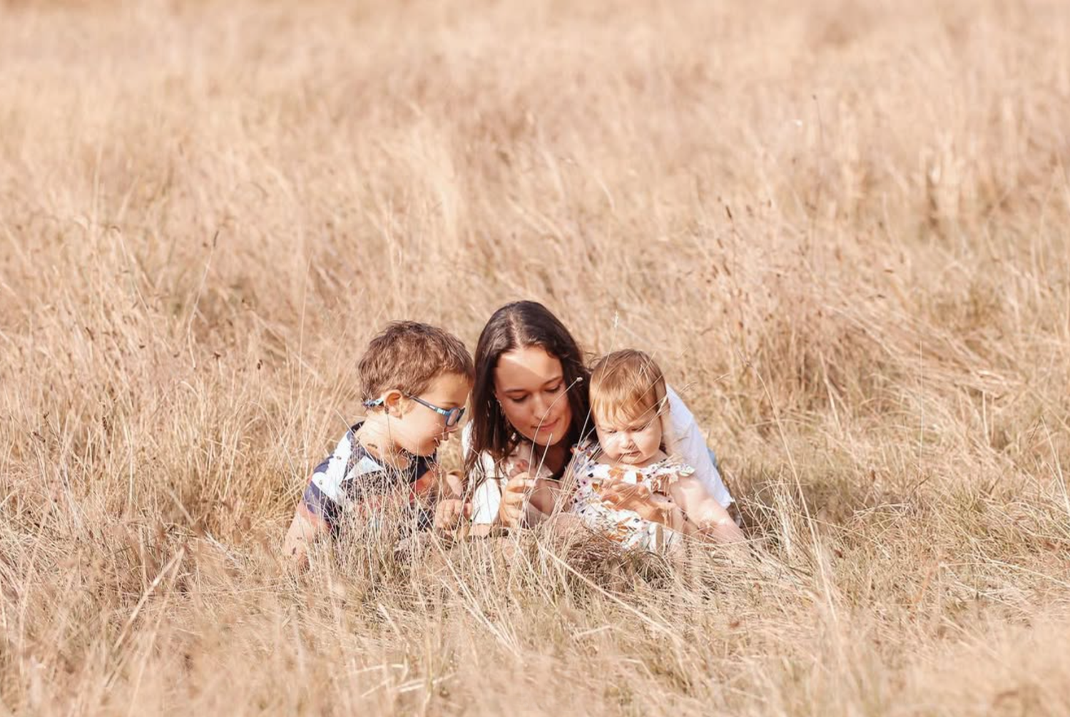 Toddler girl running through long grass during a golden hour family session. Story telling moments.