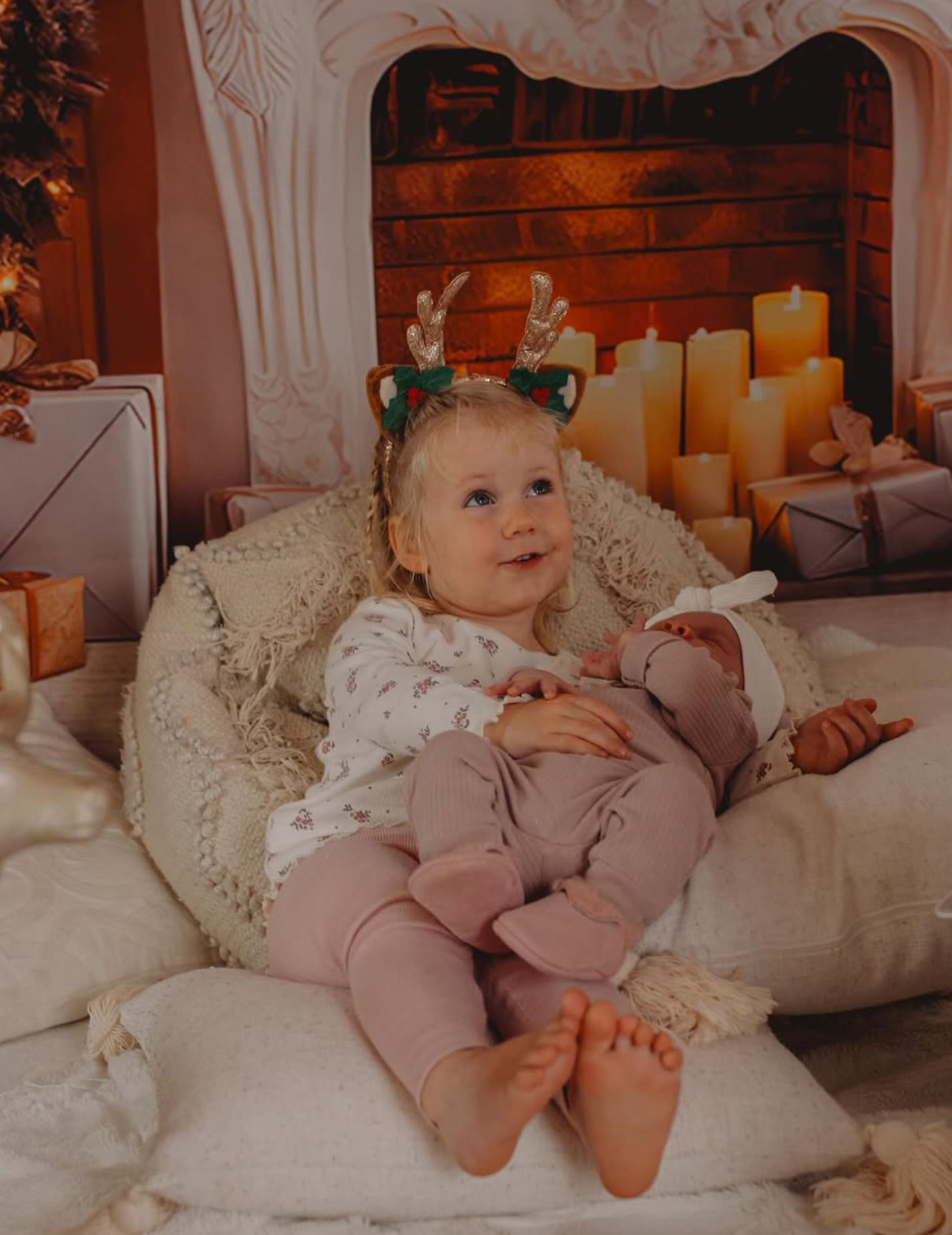 Children opening a gift box on a festive red and green holiday studio set.