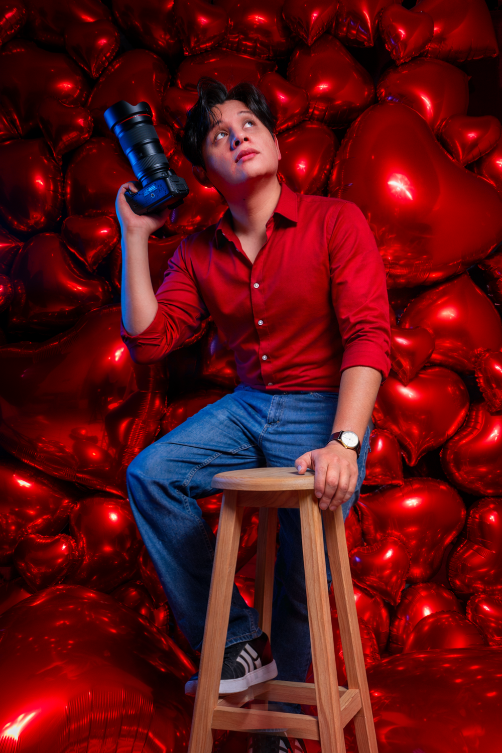 Retrato editorial de Alex Voltaire para mini sesiones de San Valentín 2025, con fondo rojo de corazones y estética romántica.