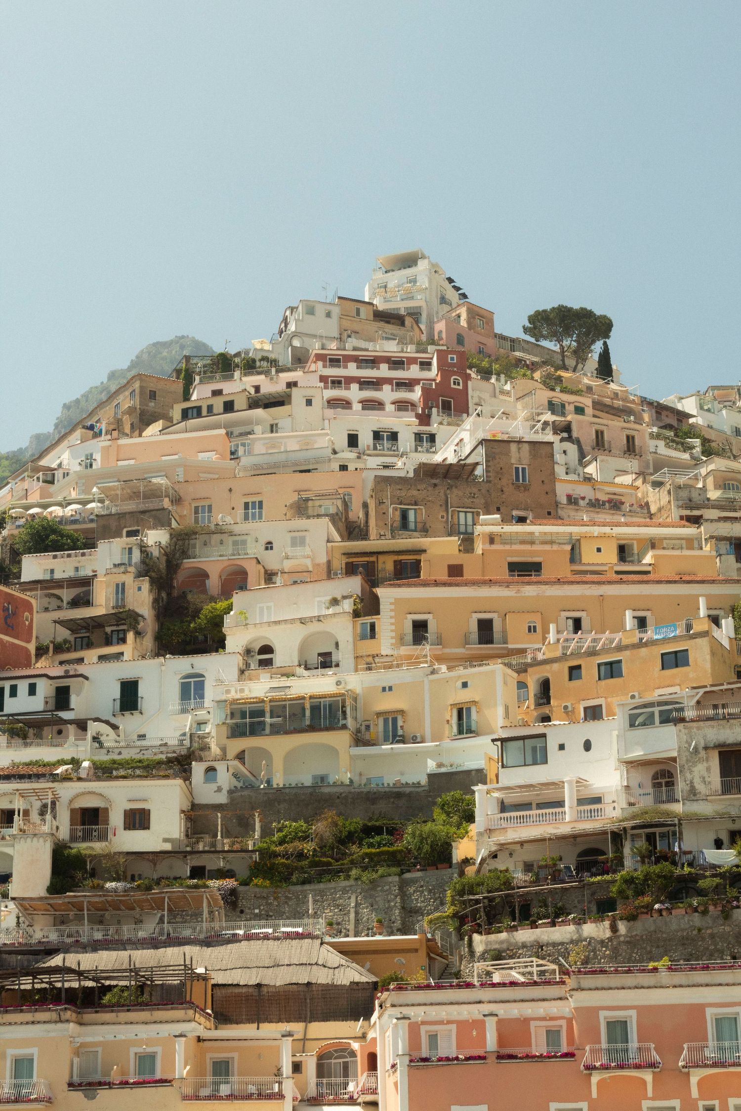 Colorful hillside houses stacked on a Mediterranean coastal town.