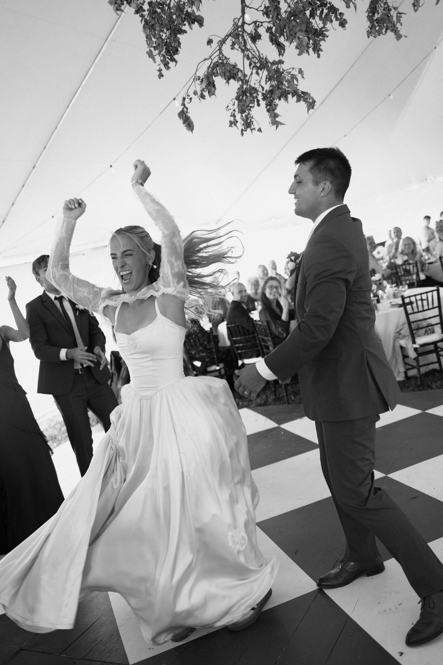 A sequence of black and white photos showing a bride and groom dancing energetically at their wedding reception.