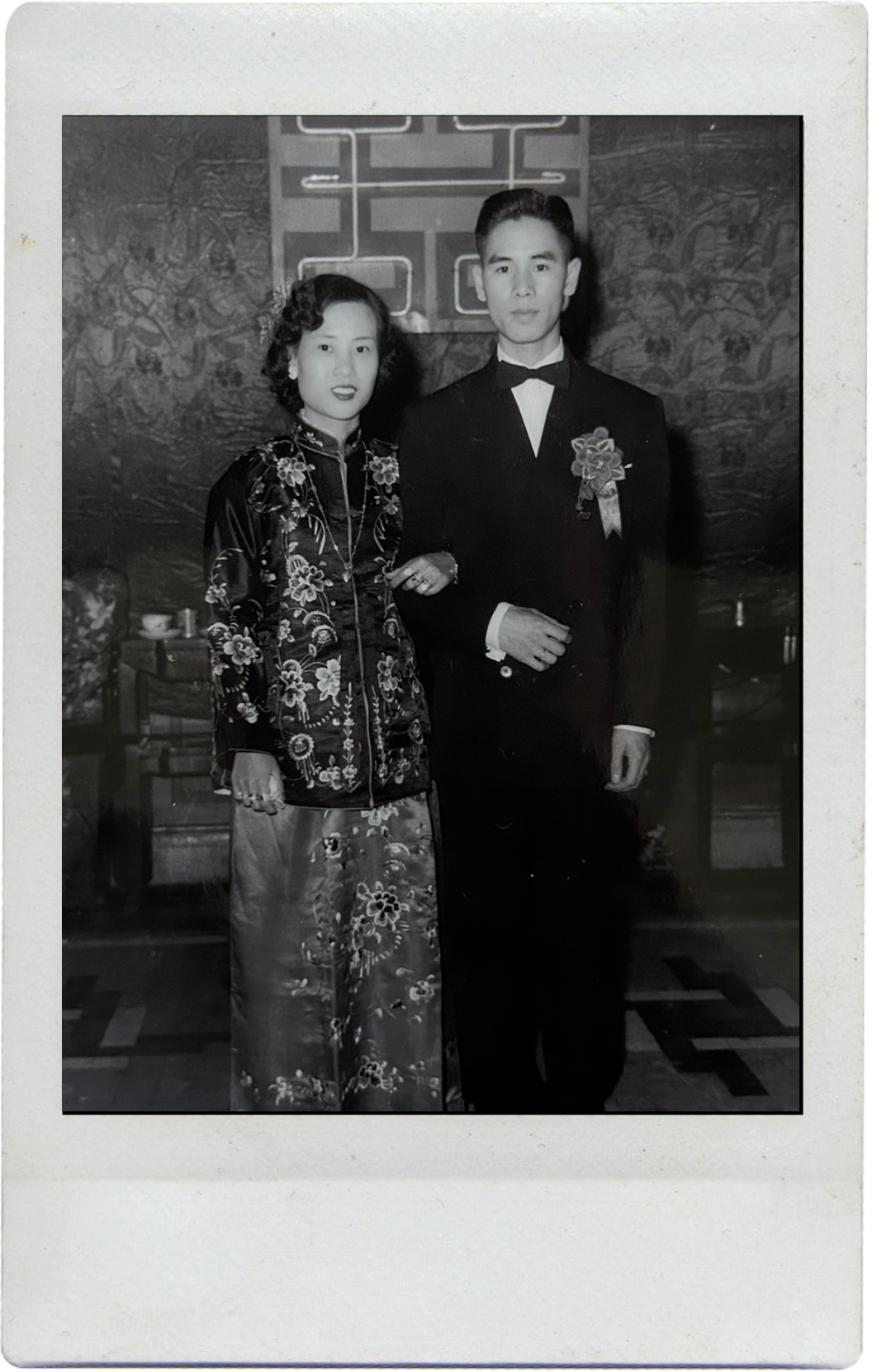 A vintage black and white photograph shows a couple in formal attire, with traditional Chinese dress and a tuxedo.