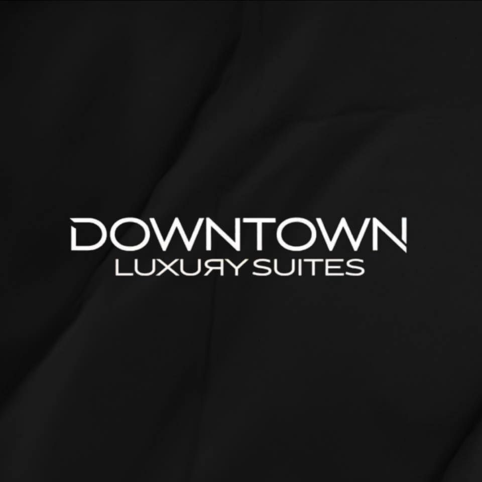 Black and white text logo reading 'DOWNTOWN LUXORY SUITES' on dark background.