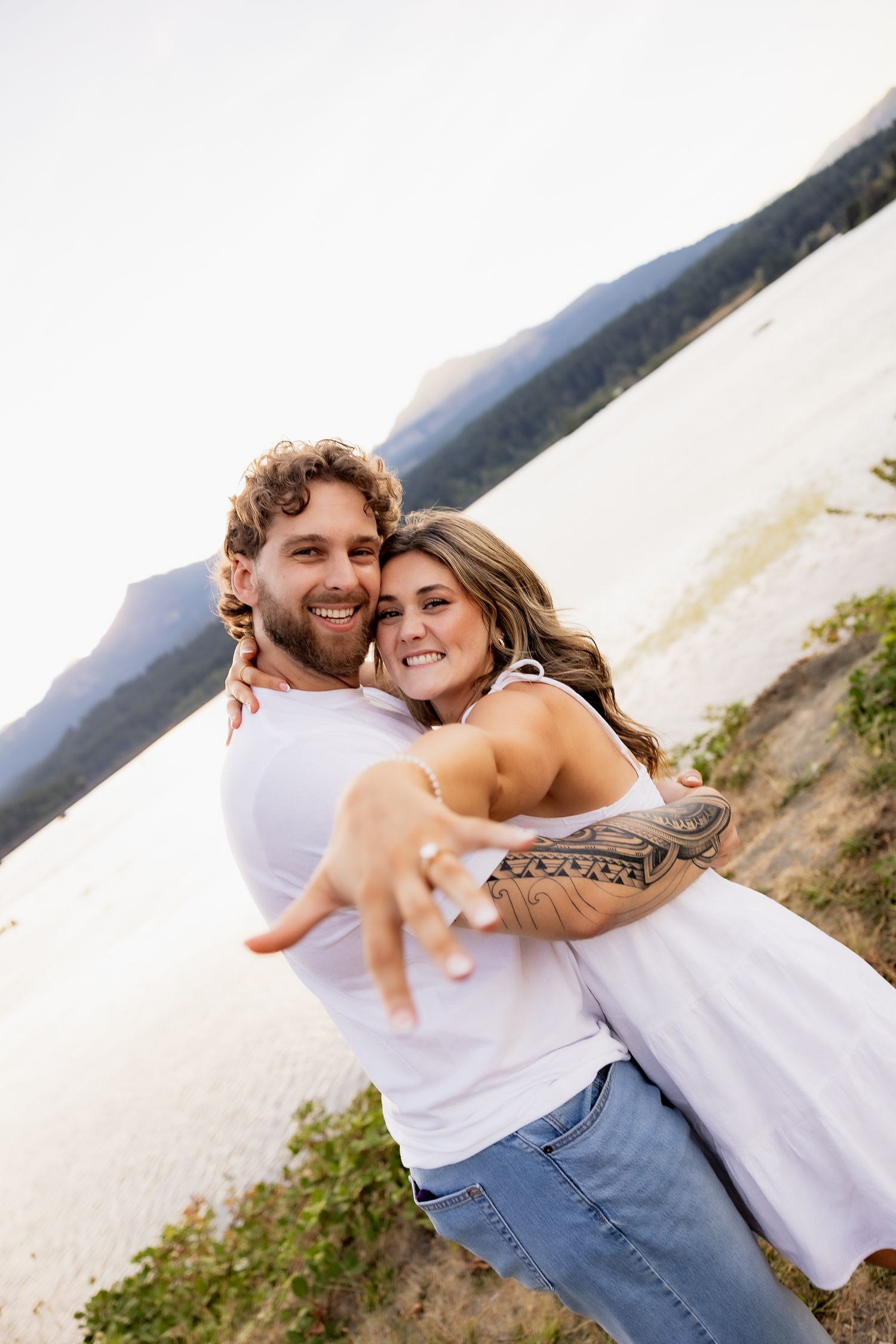 Romantic couple in casual white outfits sharing tender moments by the coastline.