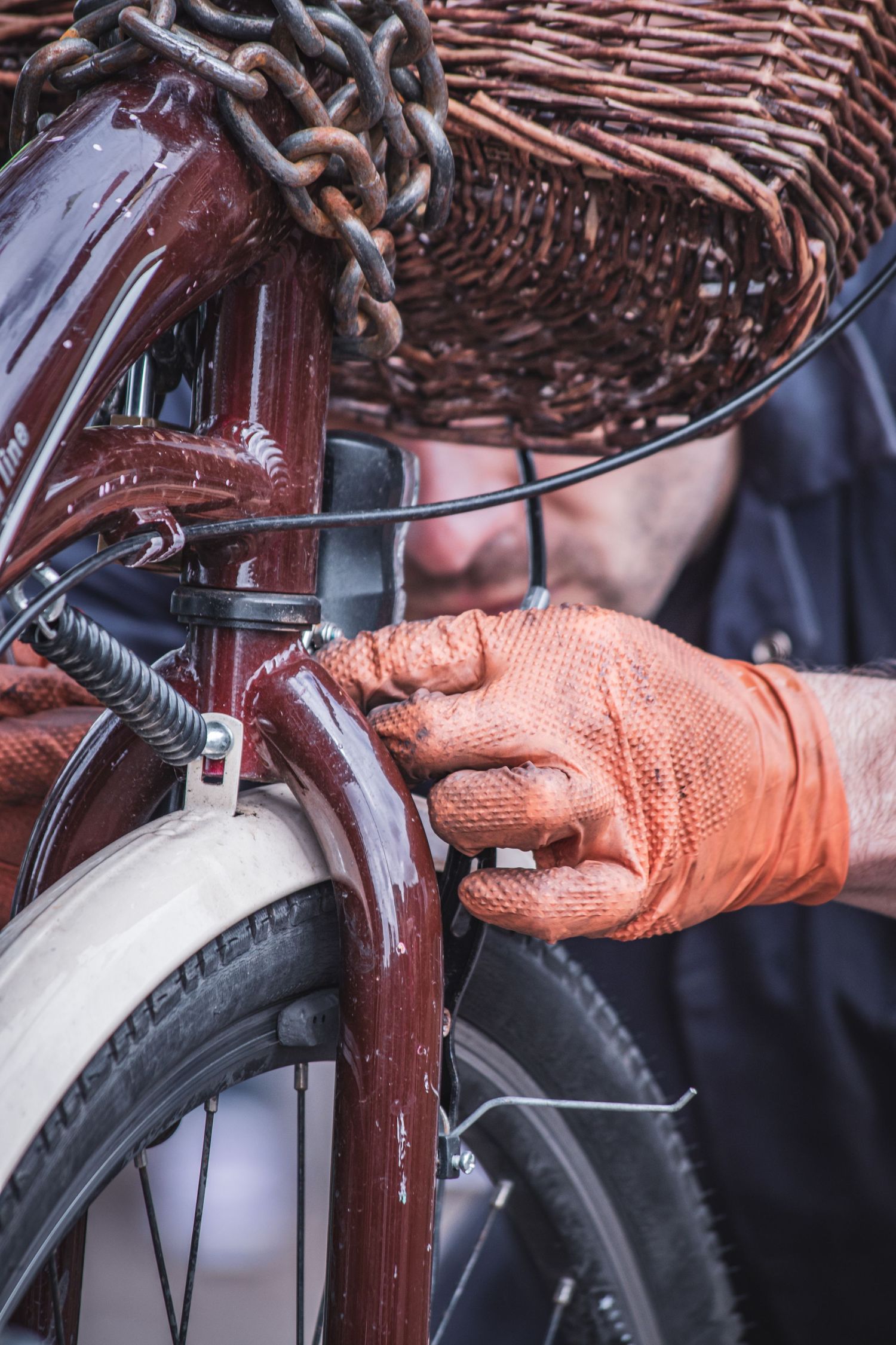 Close-up sequence showing hands in orange gloves installing or adjusting a bicycle brake system.