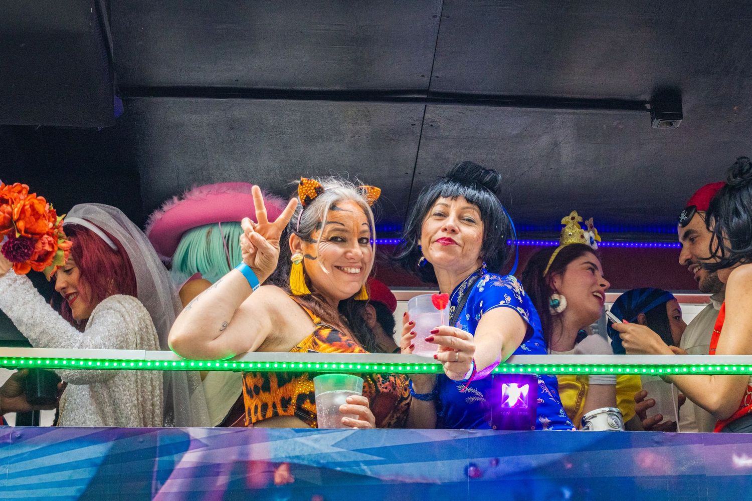 People enjoying a lively celebration with colorful lights and decorations at an entertainment venue.