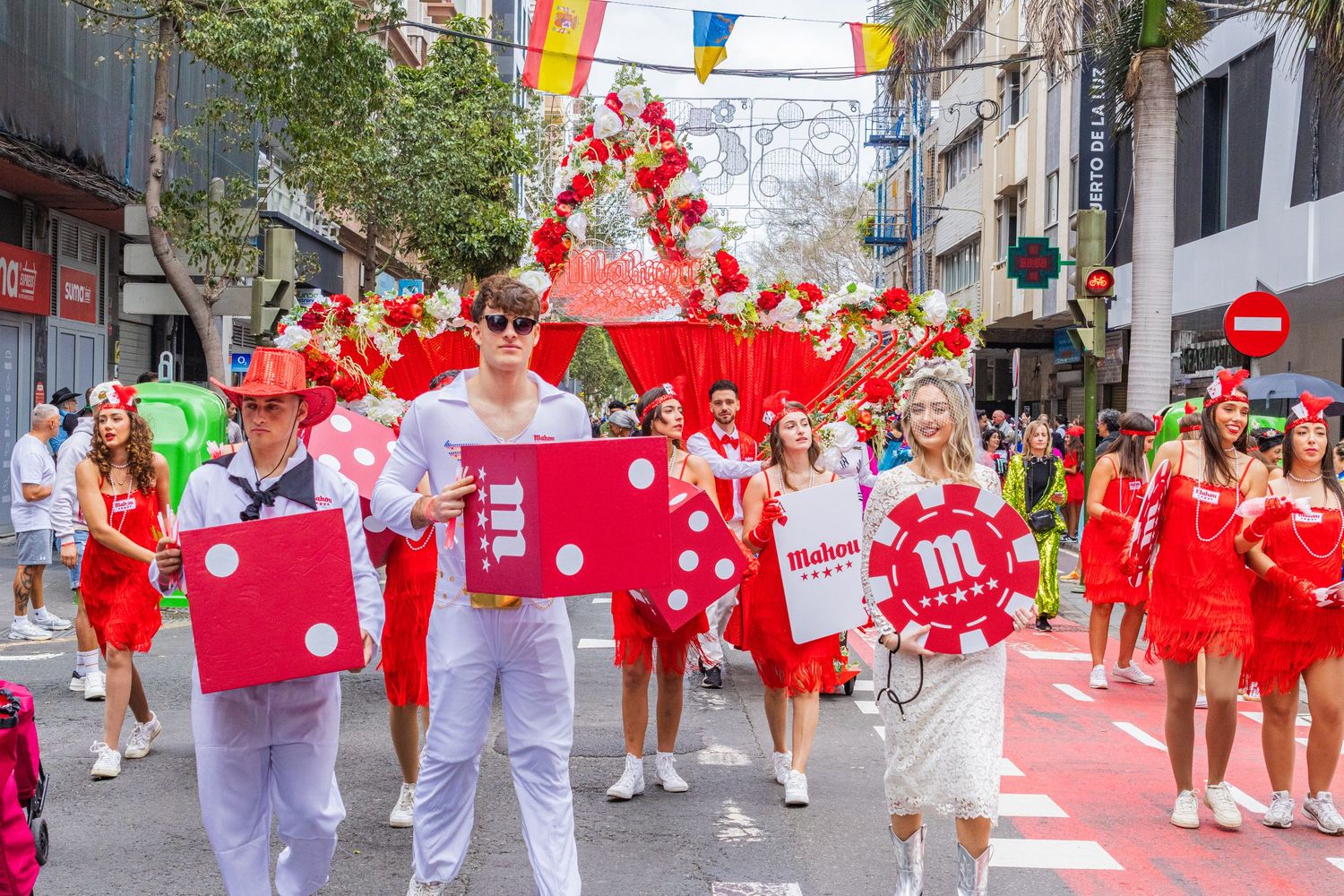 A festive parade with red lanterns and colorful banners celebrates Chinese New Year in a city street.
