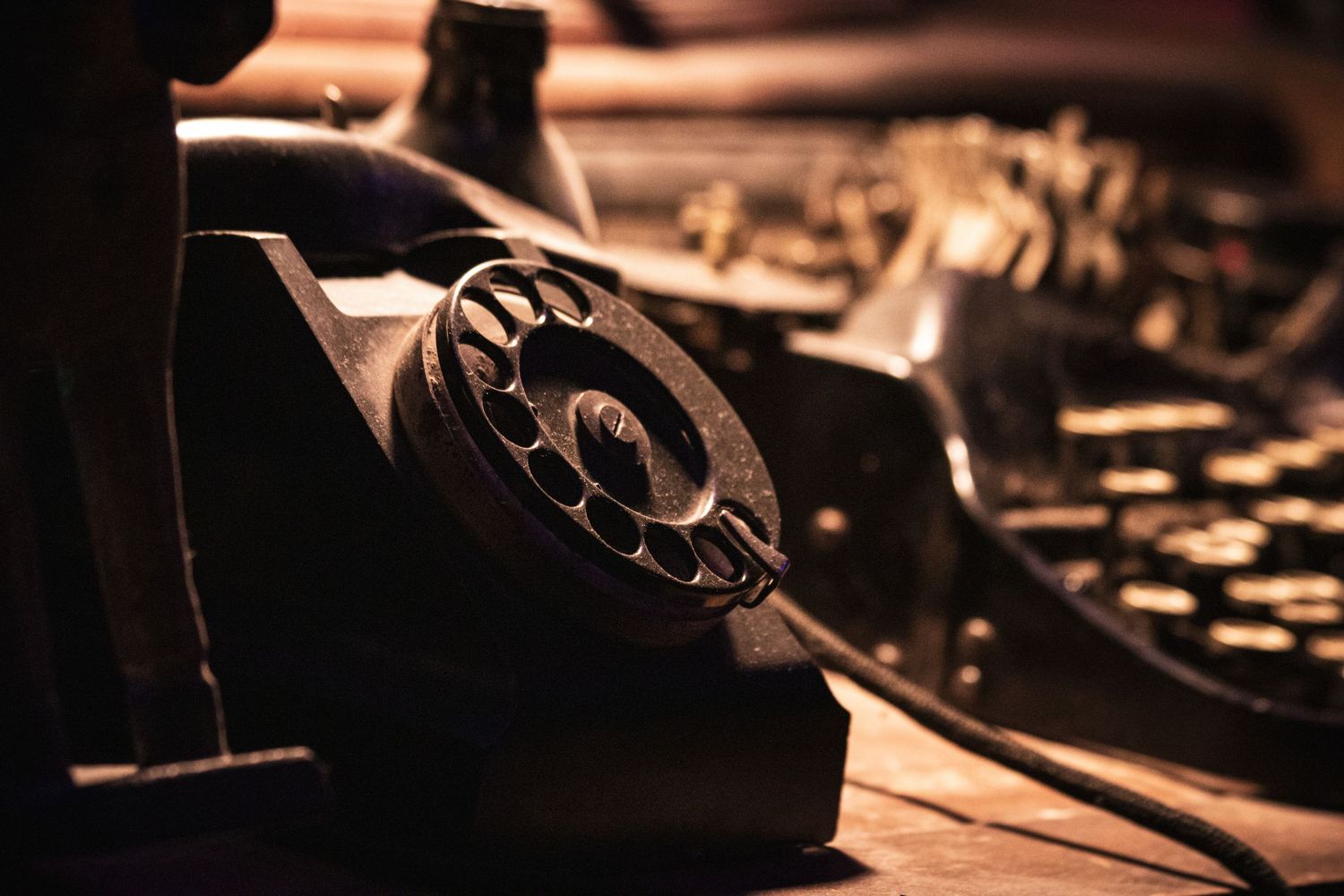 Close-up view of a vintage rotary telephone dial in warm lighting with blurred background.