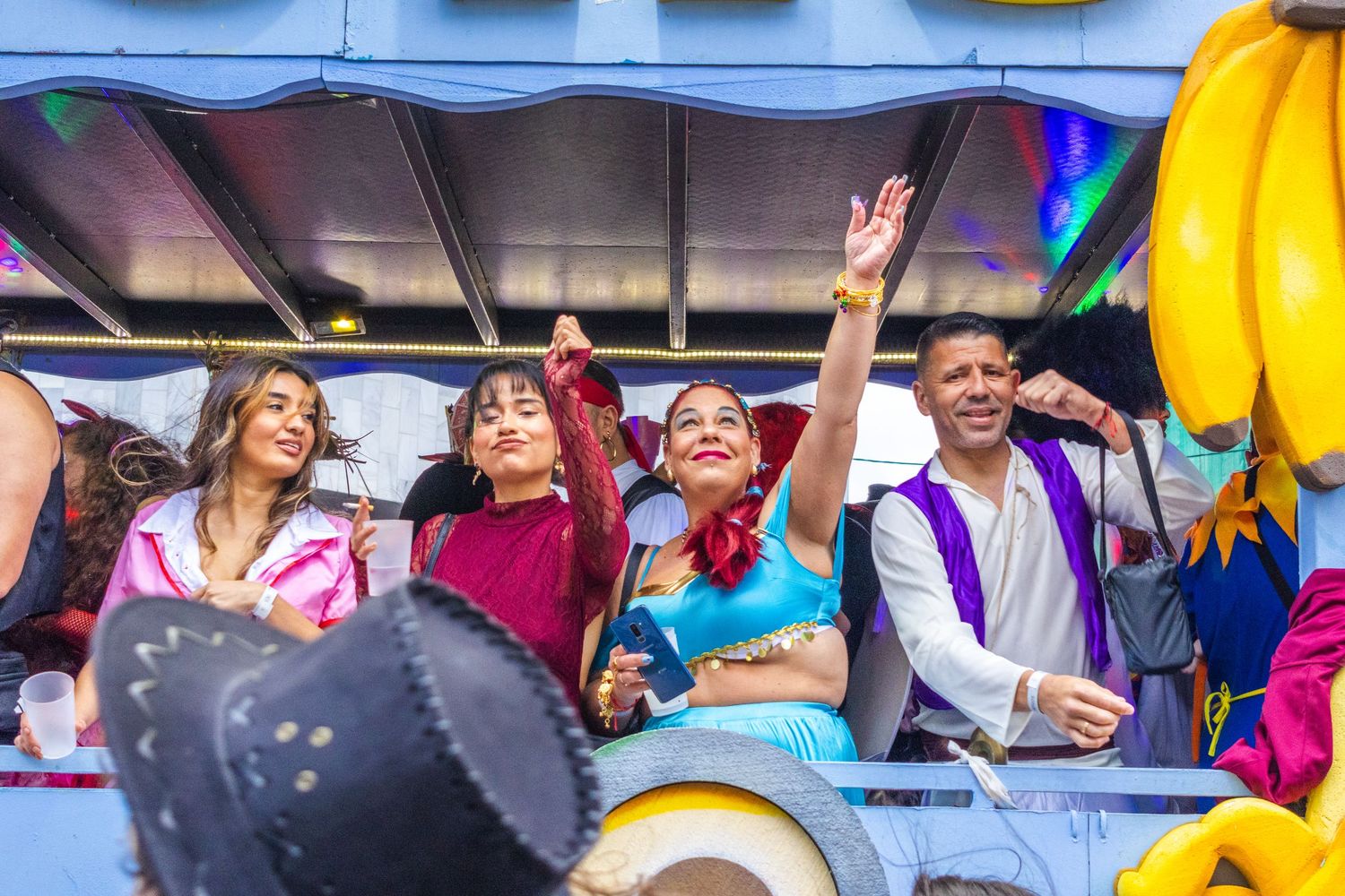 Colorful crowd of sports fans cheering and waving at a stadium during a sporting event.