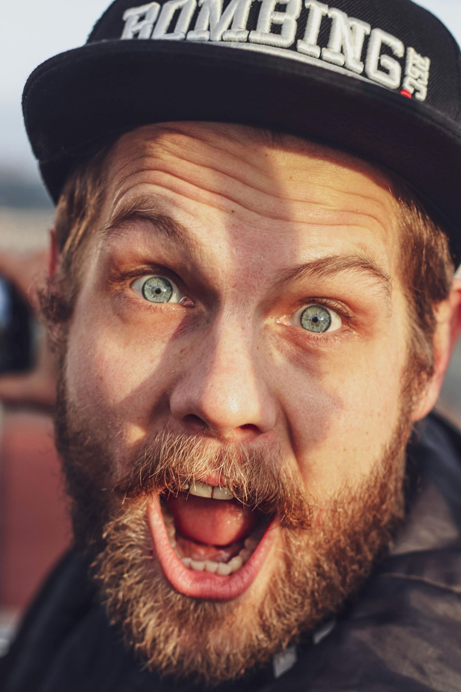 Close-up sequence showing bearded person in a cap making playful facial expressions and silly faces.