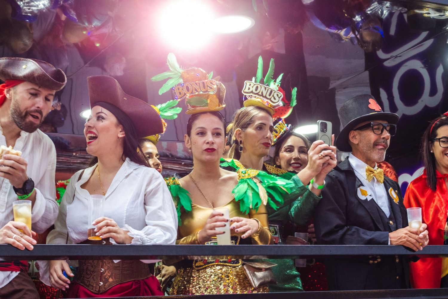 Excited fans cheer and react emotionally while watching an intense sports game in a crowded venue.