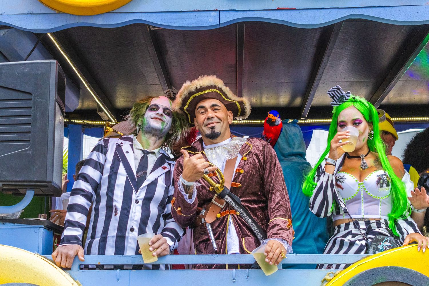 Three costumed performers in steampunk and circus themed outfits pose together at an entertainment event.