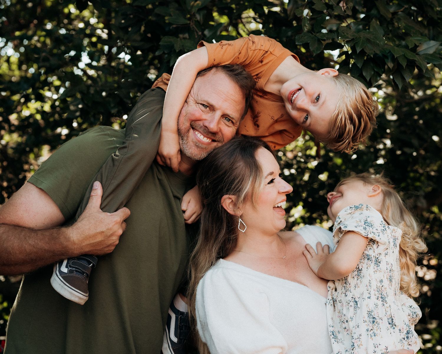 A couple shares joyful candid moments together during an outdoor photo session in a natural setting.