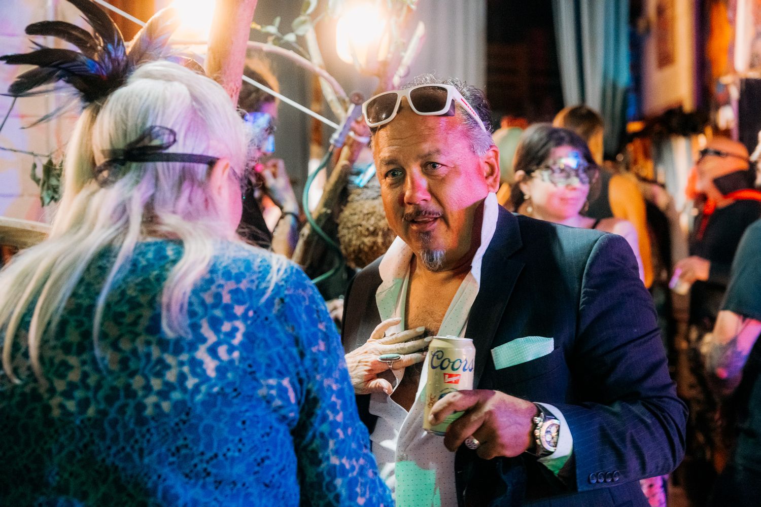 People dancing and celebrating at a lively party with colorful lights and festive atmosphere.