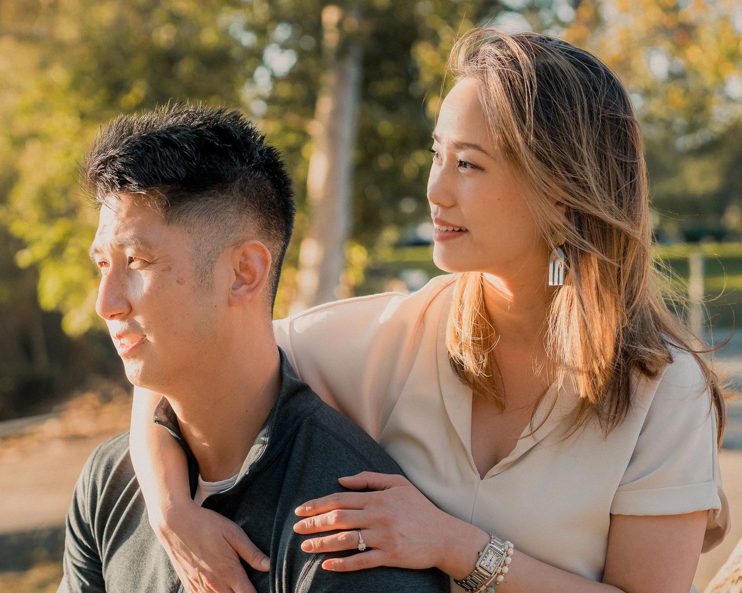 Couple sharing intimate moments in autumn park setting with golden sunlight filtering through trees.