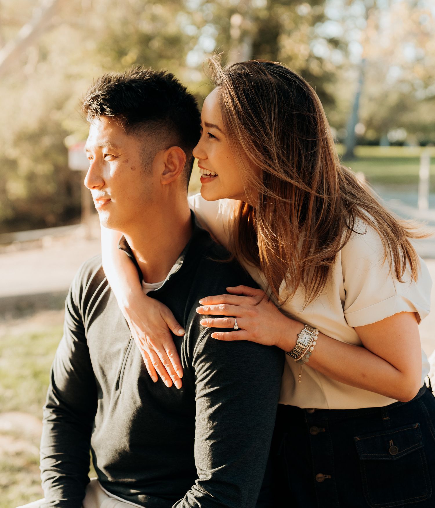 Romantic couple sharing intimate moments in a sunlit outdoor setting during a photo session.