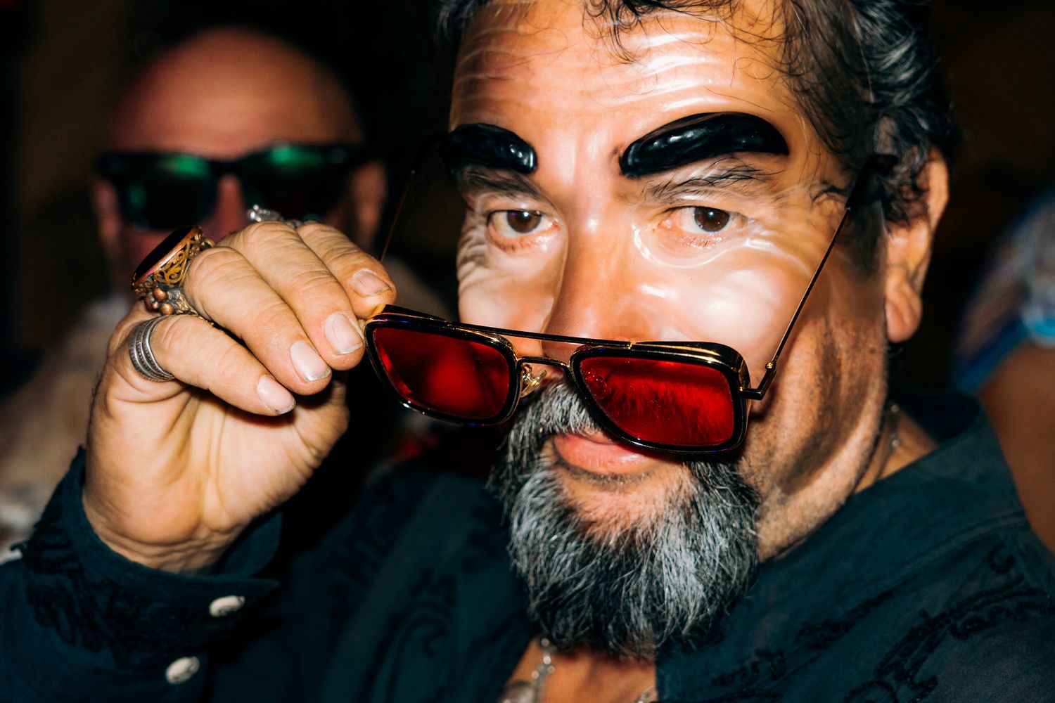 A series of close-up shots showing someone wearing different colored sunglasses in a dimly lit setting.