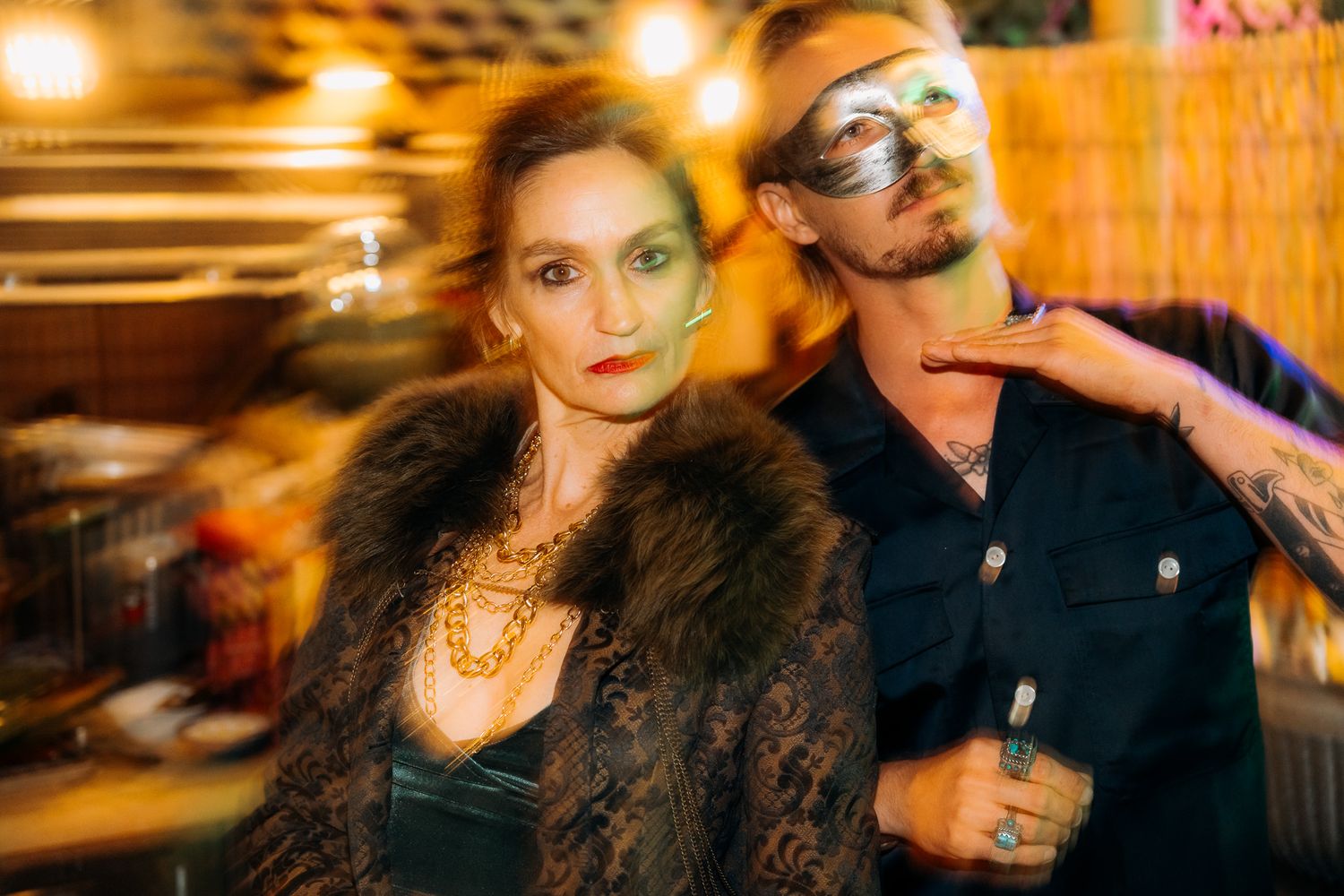 A blurred motion shot captures the energy and movement at a bustling nighttime social gathering.