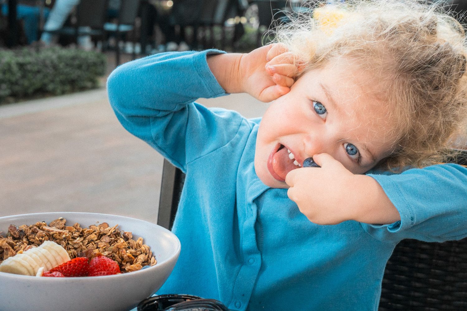 Pretty blue eyed girl having blueberry and strawberry breakfast and a playful expression of joy - Mariano Alvarez event photography, OC, CA