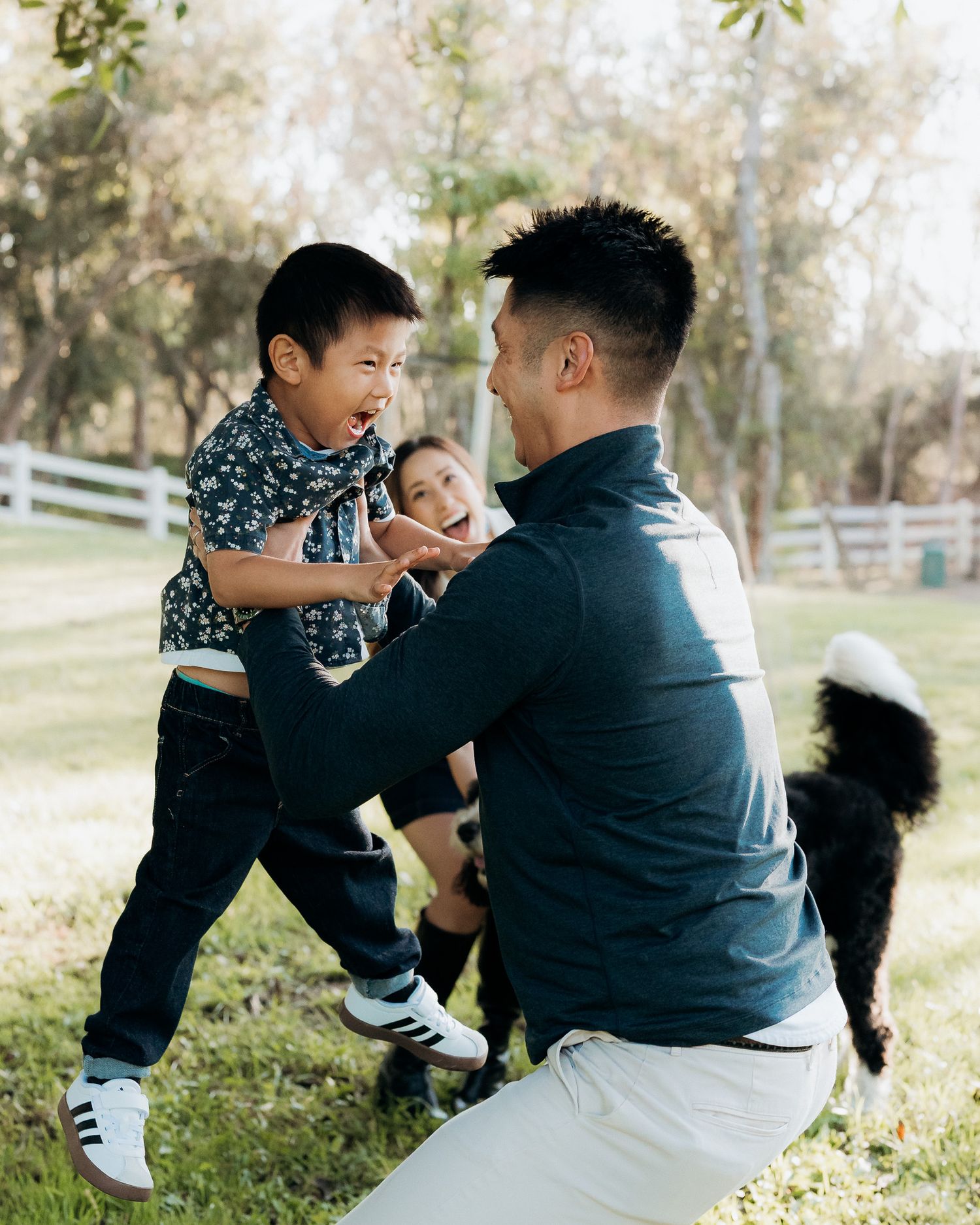 A father tossing ing his son in the air with mom watching as they laugh at the boy's excited reaction. Mariano Alvarez Photography.