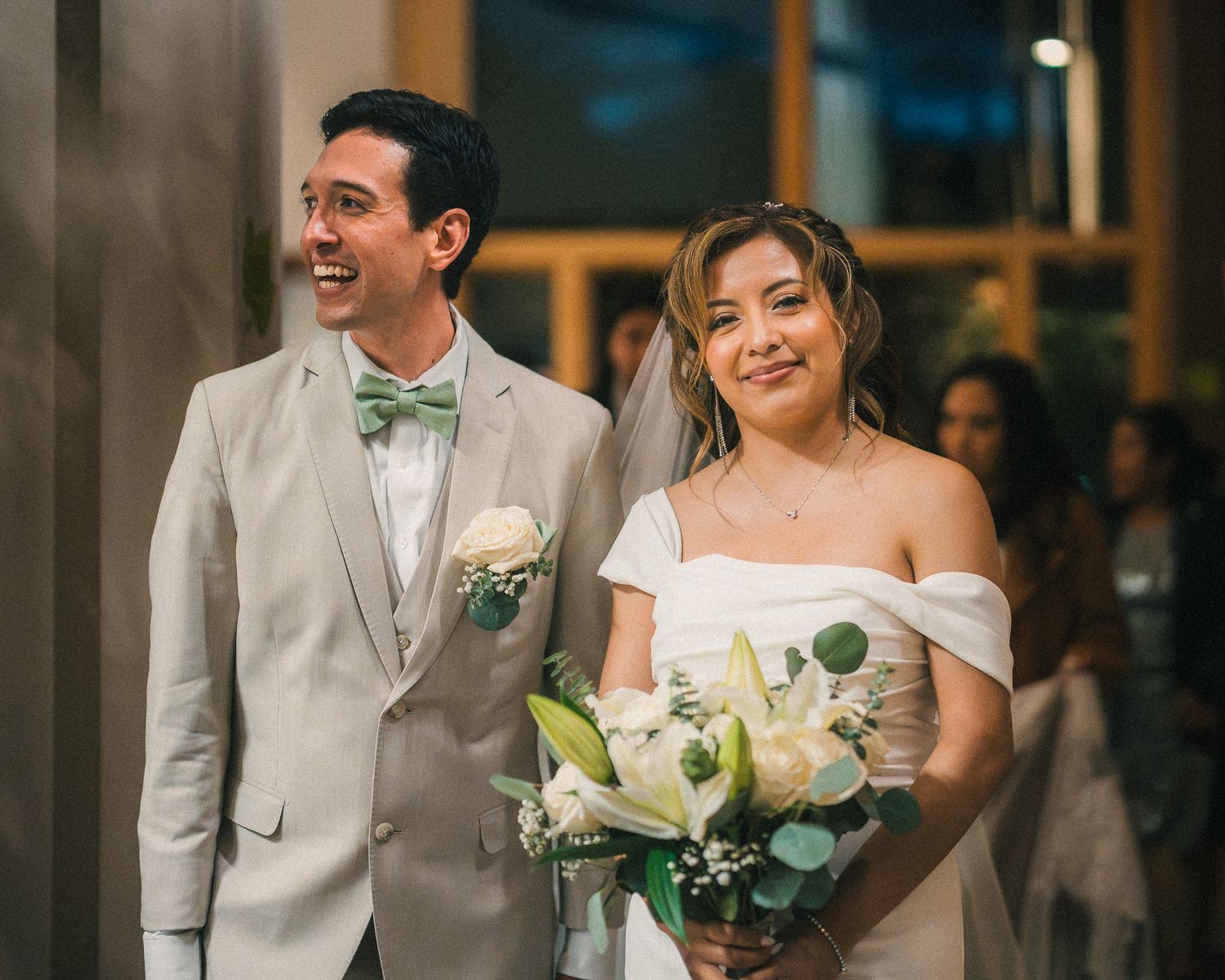 A joyful wedding couple shares a candid moment while walking together in formal attire.