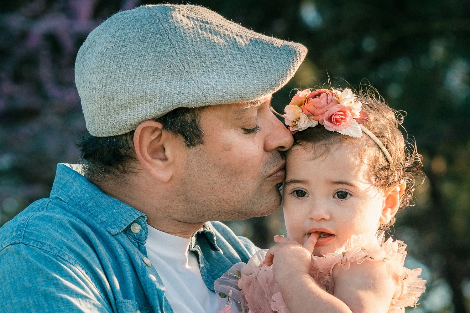 Sweet family moment captured in warm sunlight during an outdoor photo session.
