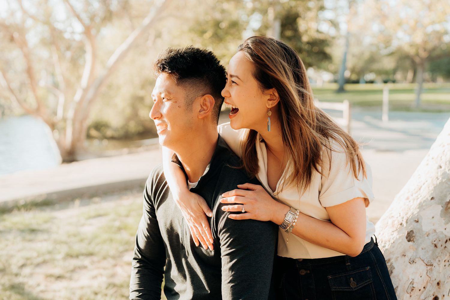 A couple shares intimate moments outdoors during a romantic photoshoot in warm natural lighting.