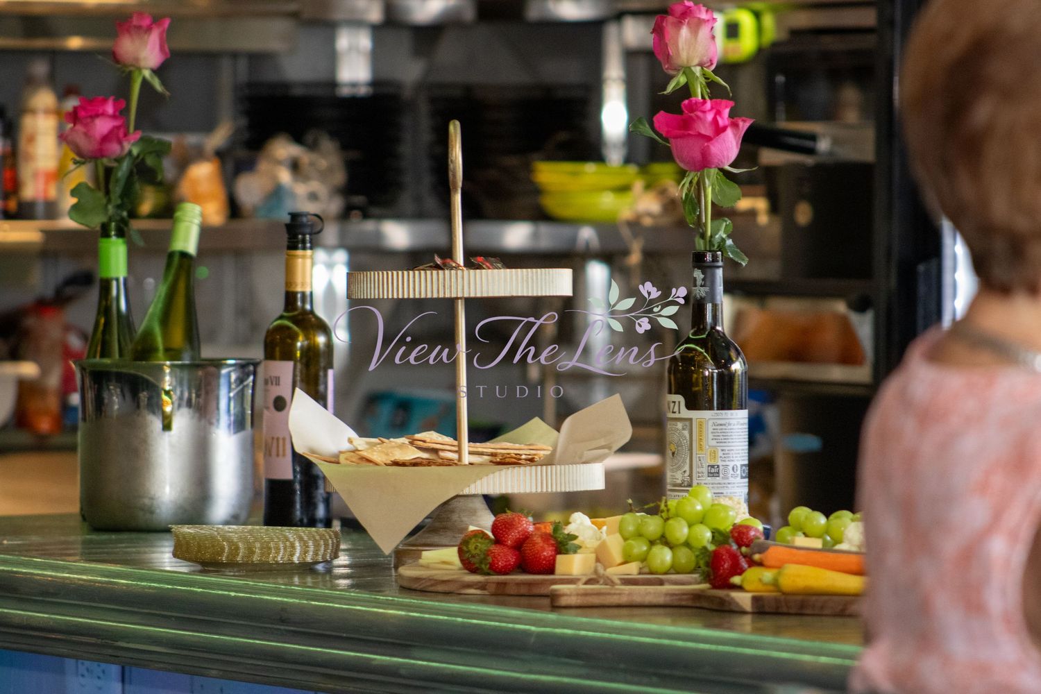 Event catering display featuring charcuterie, fresh fruit, and floral décor.