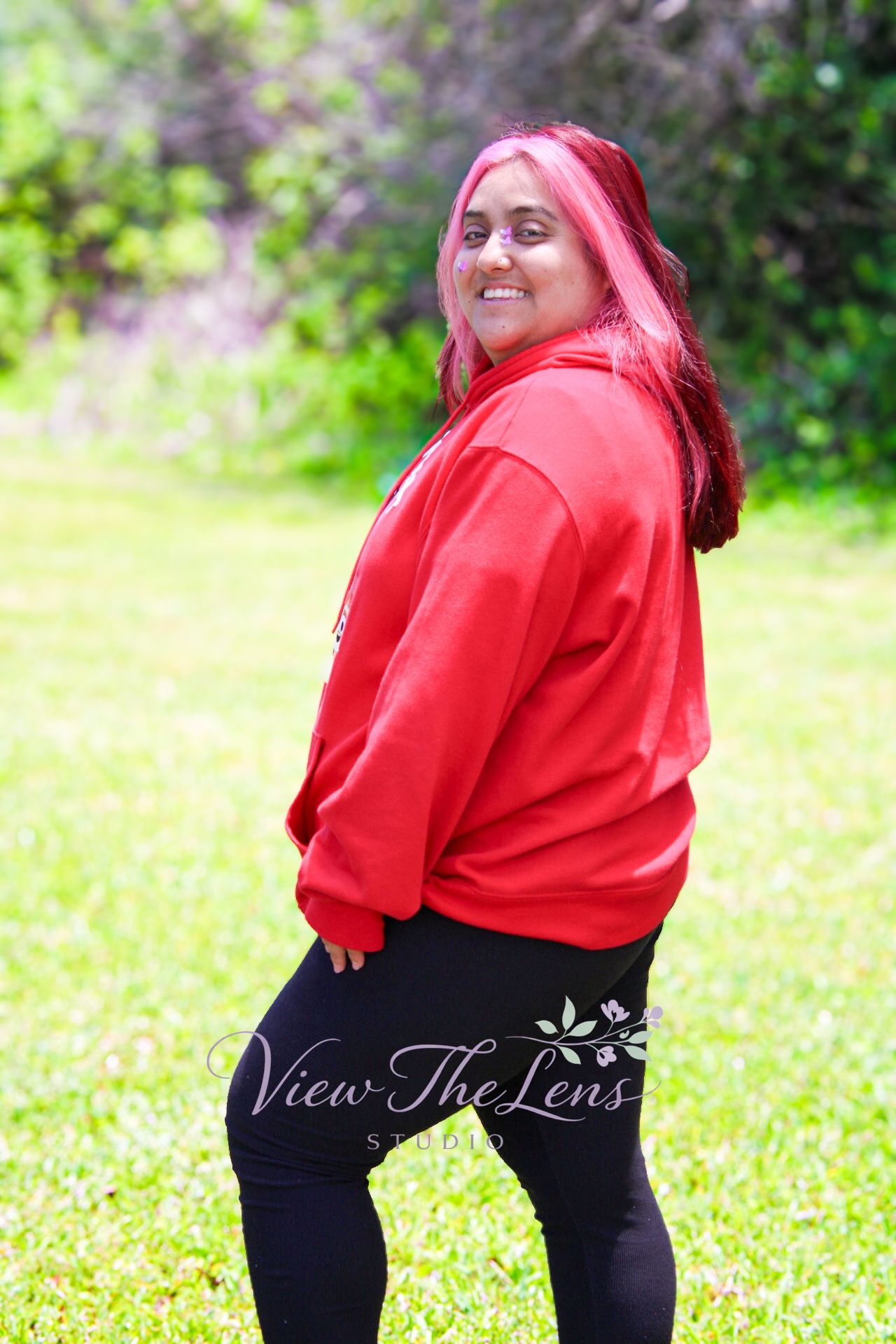 Woman smiling during an outdoor portrait session in natural light by View The Lens Studio.