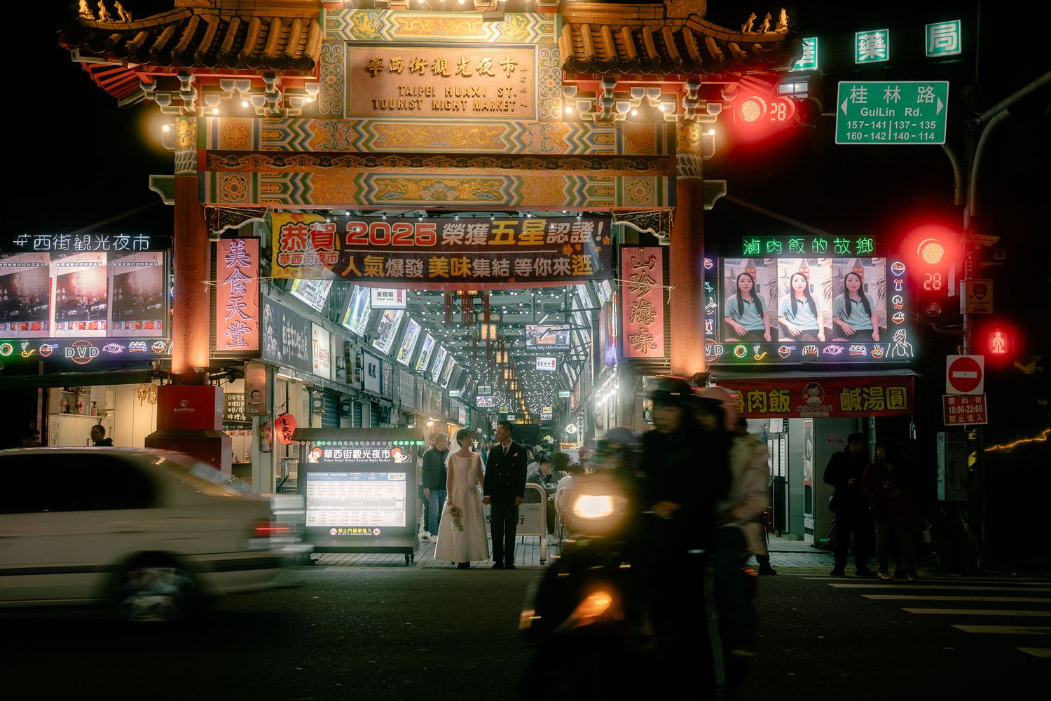 Sunny and Leo walking hand in hand through the busy Huaxi Street Night Market in Taipei