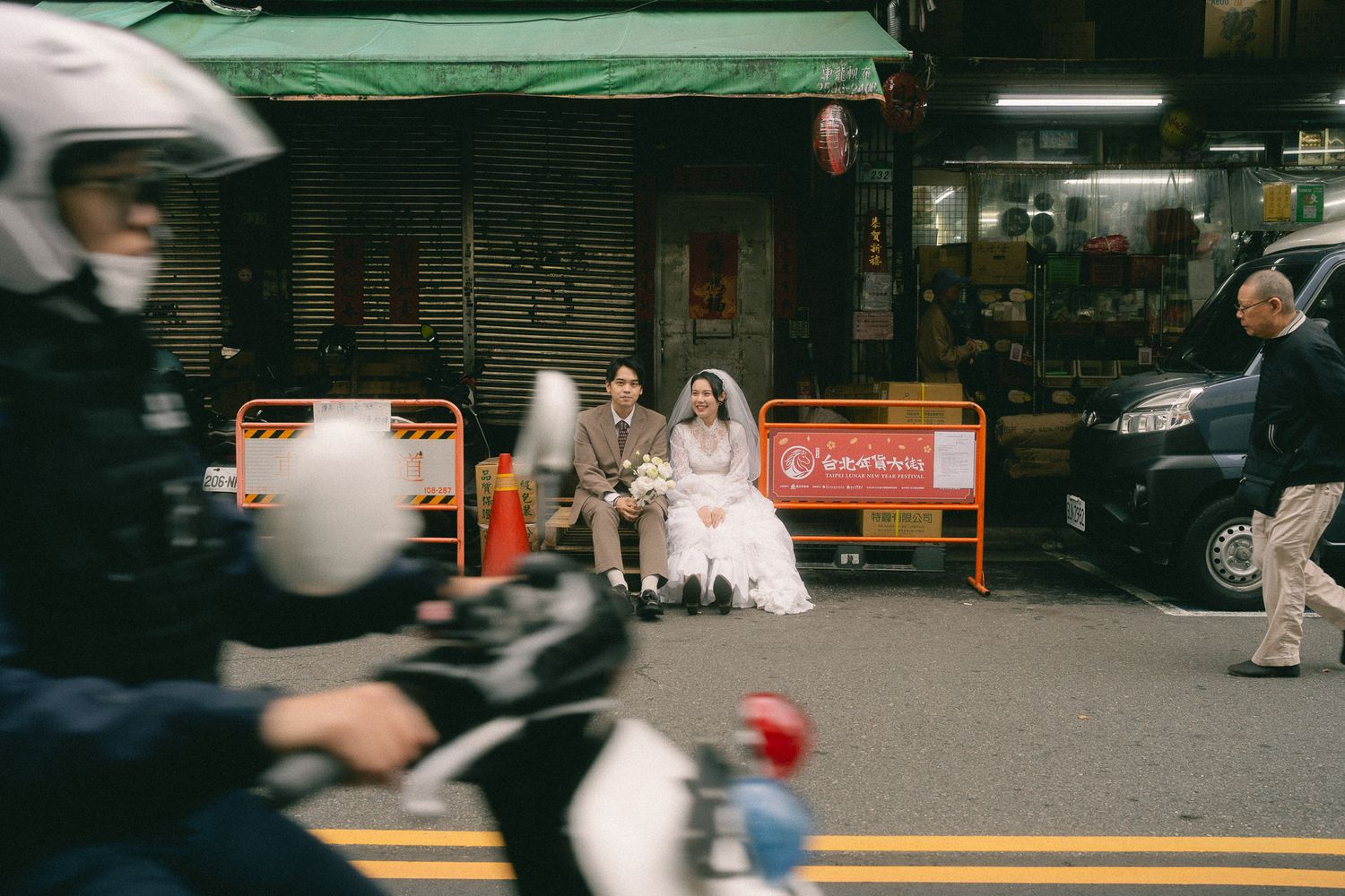 Bride and groom sitting together amid the Lunar New Year crowds during a documentary-style Dihua Street photo shoot