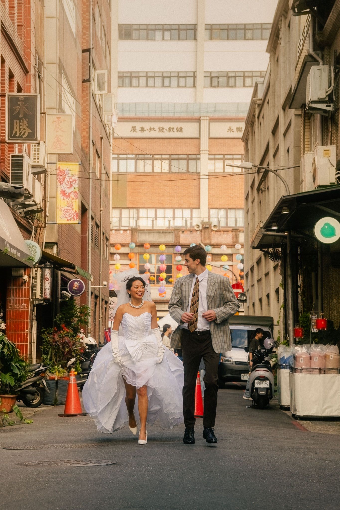 Cinematic Taipei pre-wedding photography of a bride and groom walking through an old city street