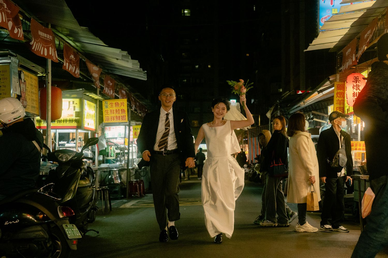 Sunny and Leo running through Huaxi Street Night Market during their cinematic Taipei pre-wedding photoshoot