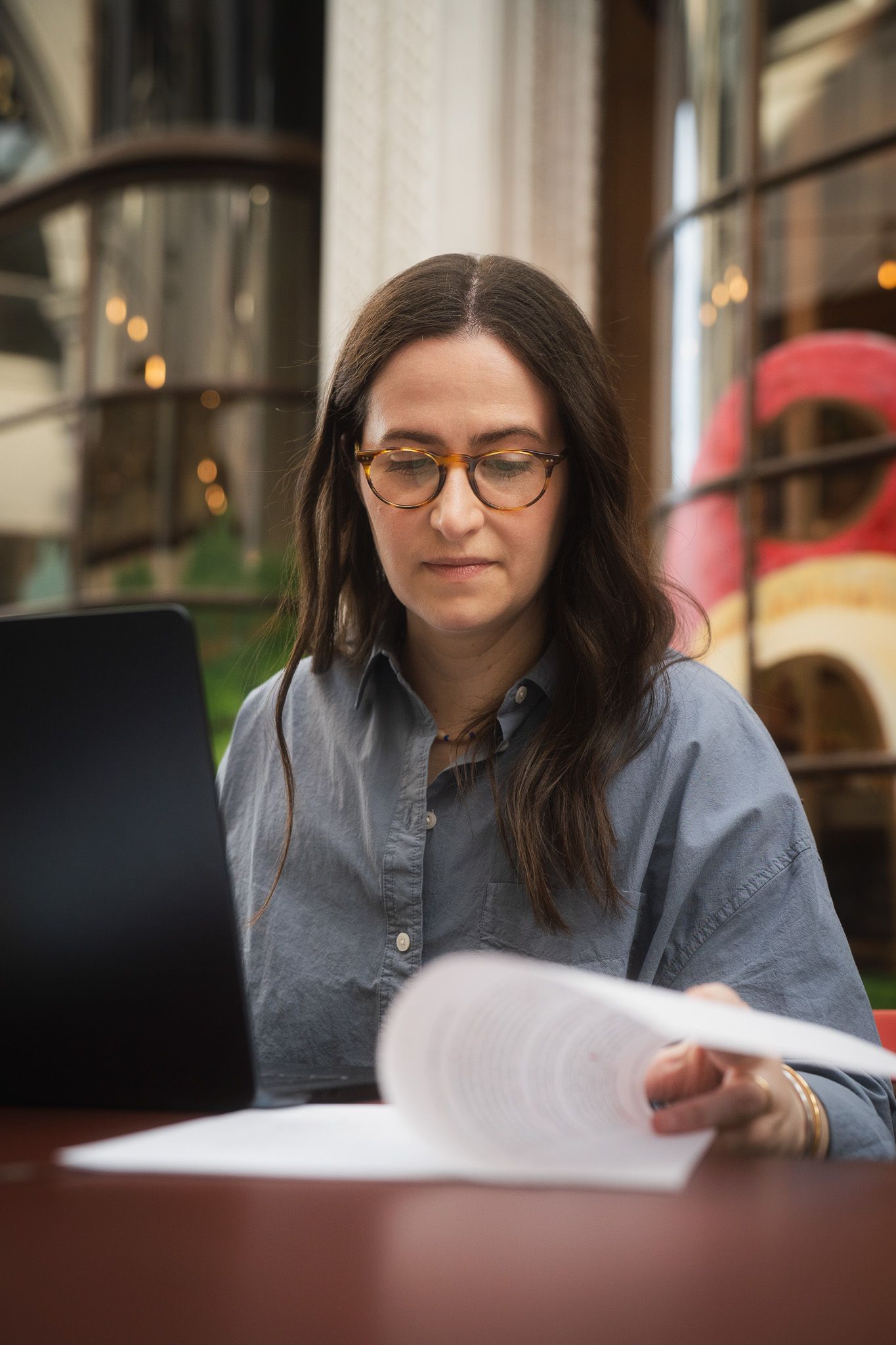 Taipei personal branding portrait of a copywriter reviewing papers at a laptop