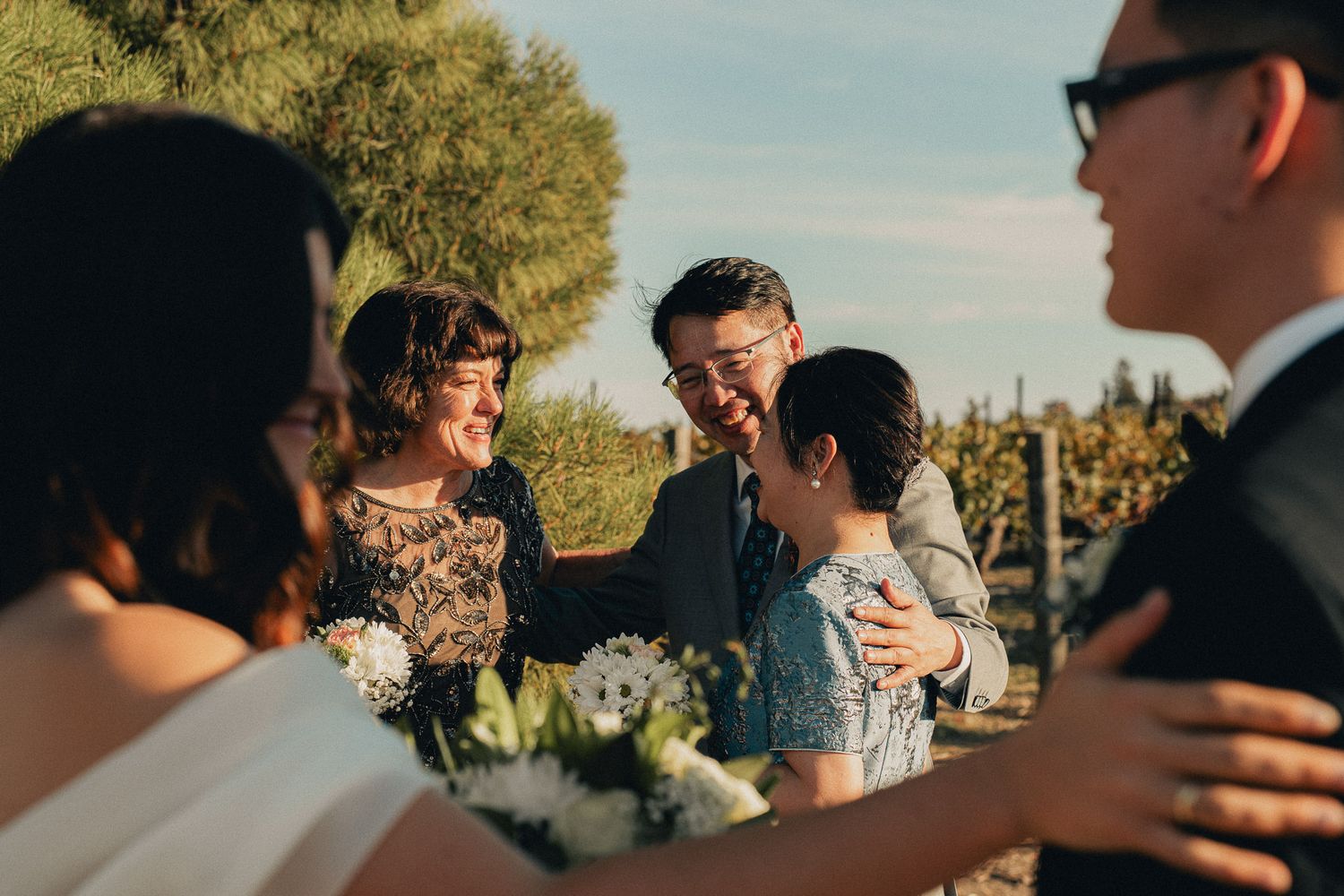 Intimate outdoor wedding ceremony with guests embracing at golden hour in Taiwan