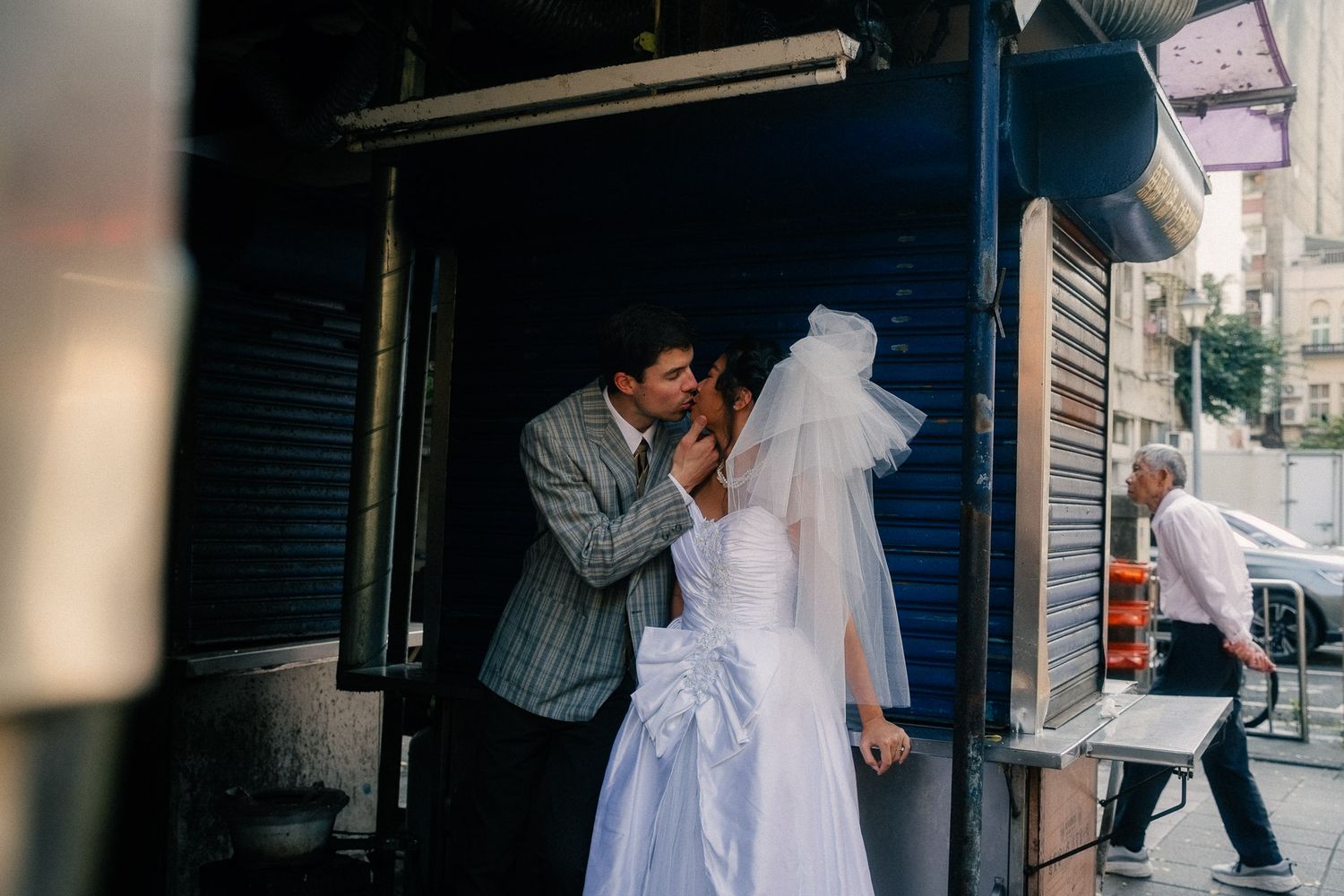Cinematic Taipei pre-wedding photography of a couple kissing outside an old Taiwanese storefront