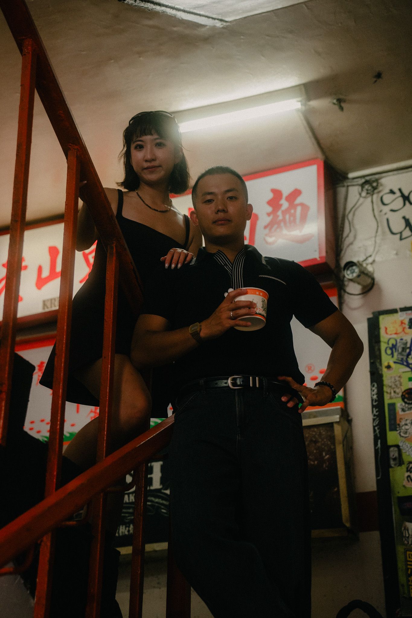 Cinematic couple portrait on a vintage staircase inside Wan Nian Building during a Taipei photoshoot