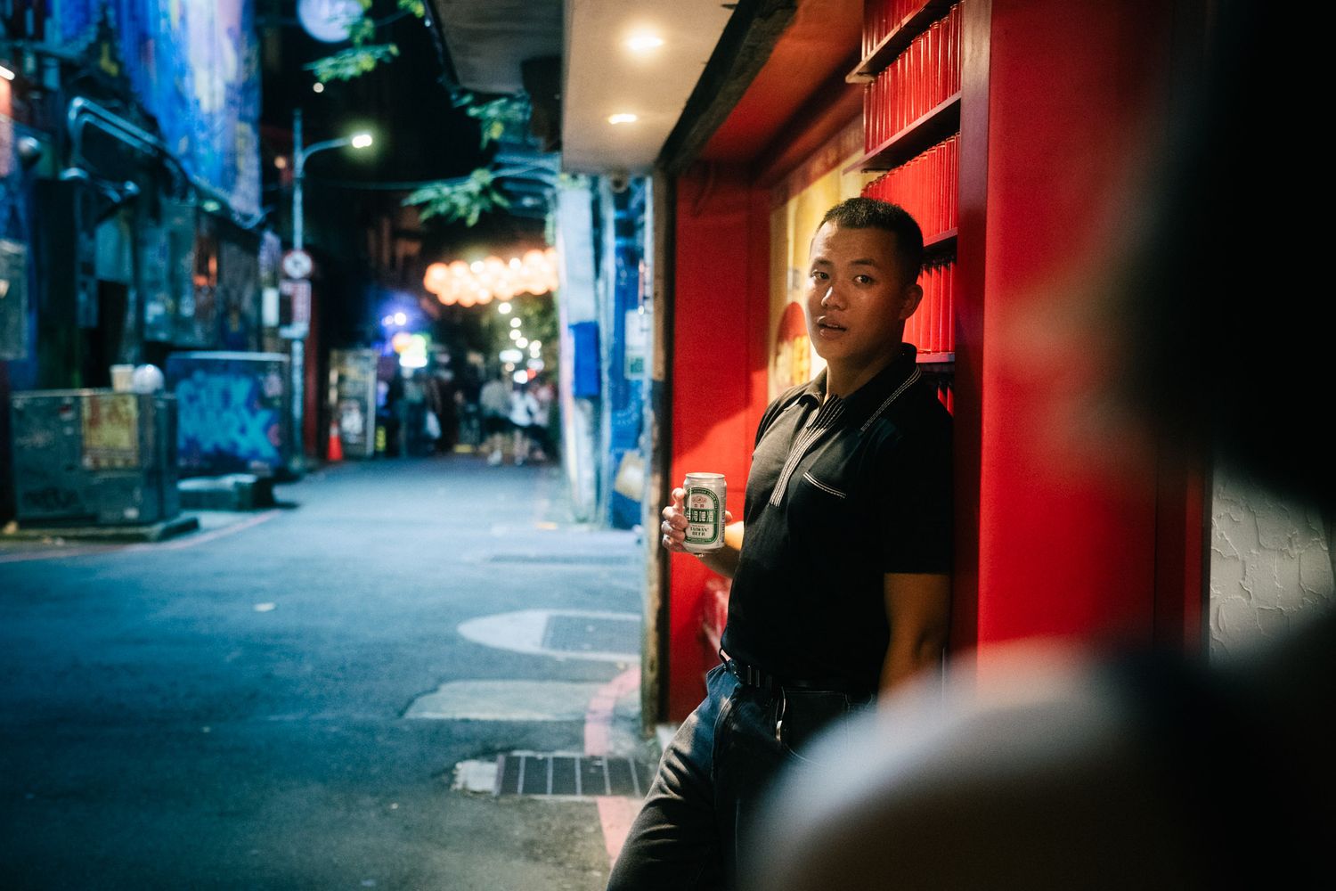 Cinematic night portrait in a Ximending alley with Taiwan Beer during a Taipei couple photoshoot