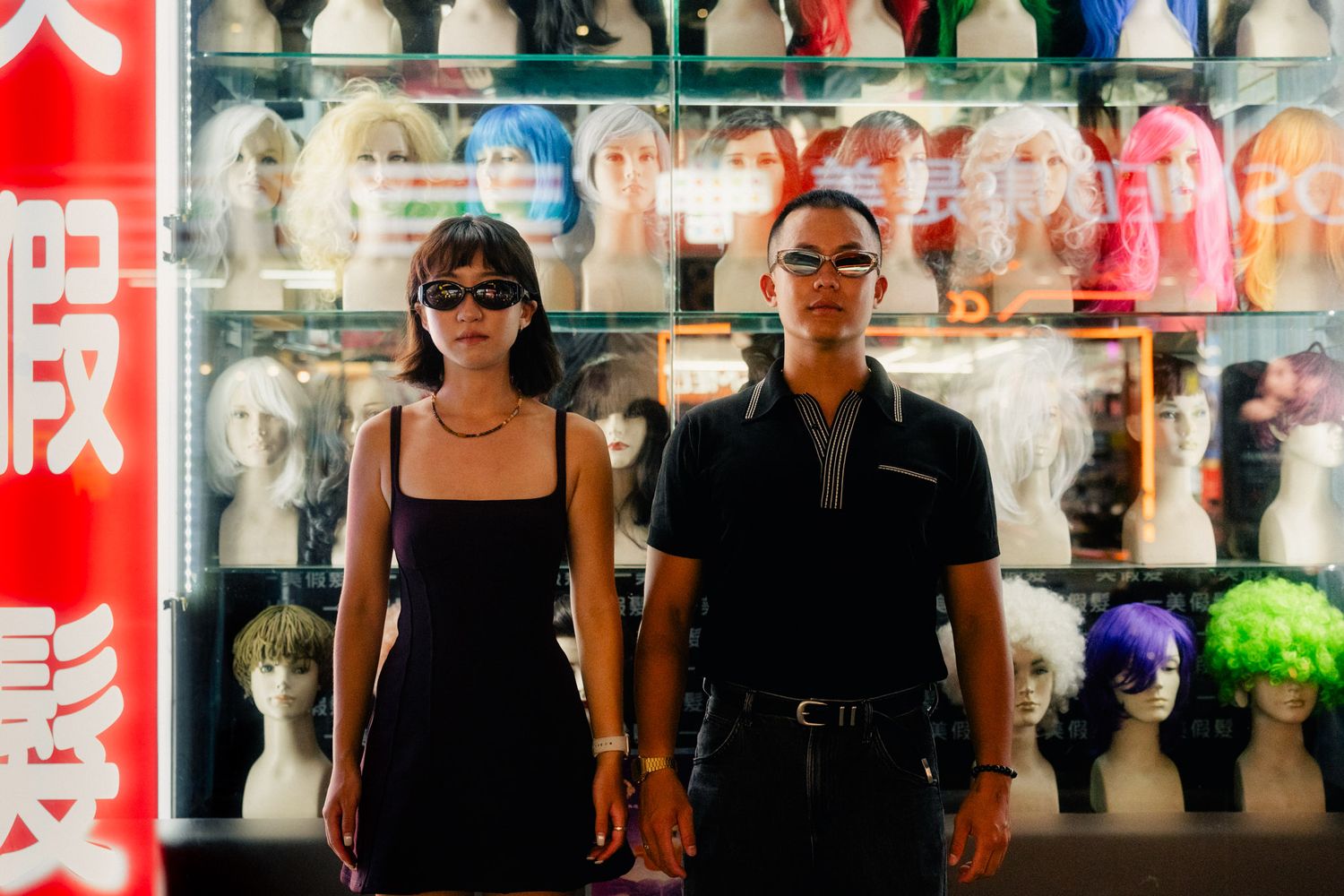 Couple posing outside a colorful wig shop during a cinematic Ximending couple photoshoot in Taipei, Taiwan