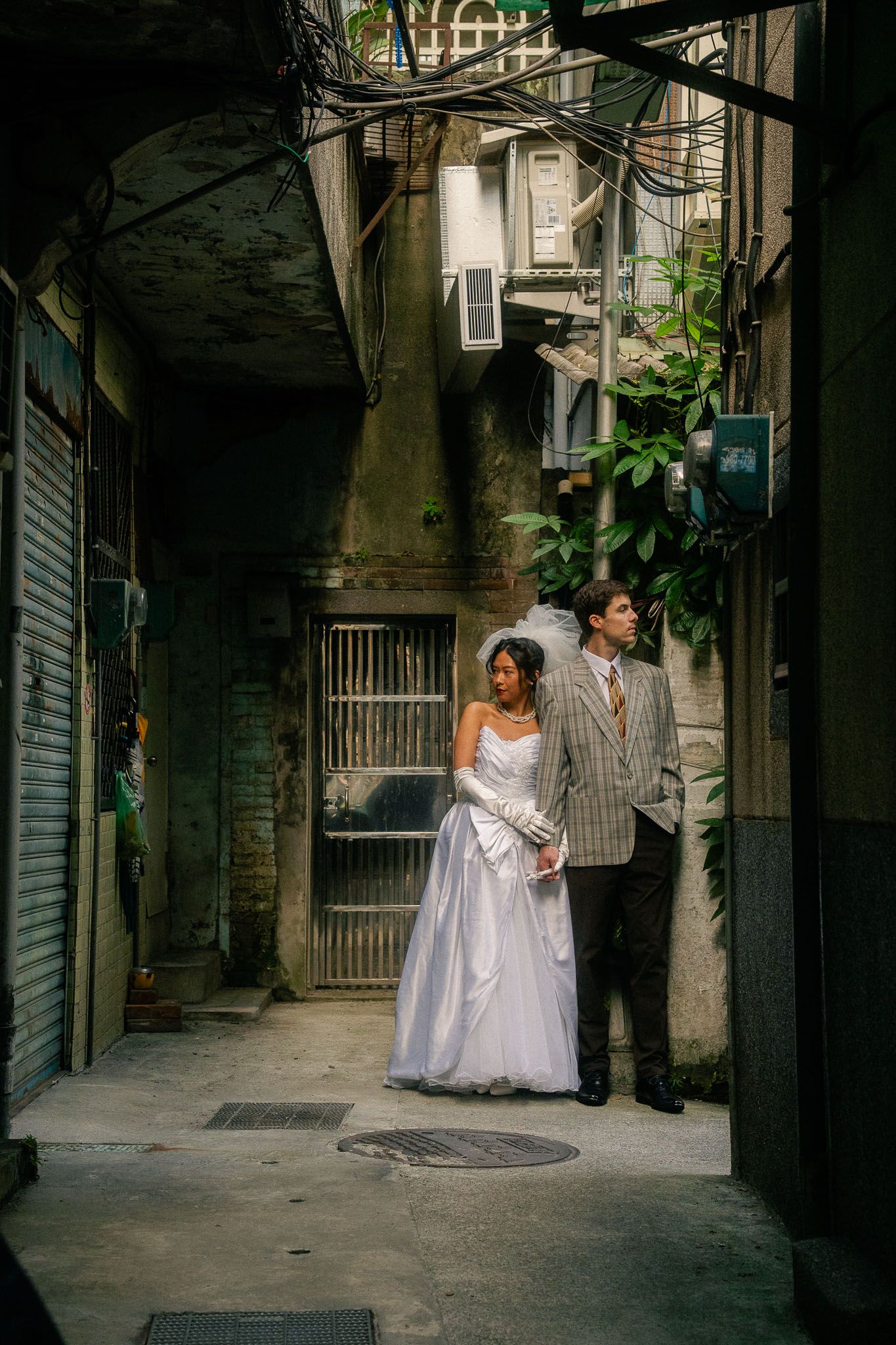 Emily and Nik posing in a shadowy alley during a cinematic pre-wedding photoshoot in Taipei