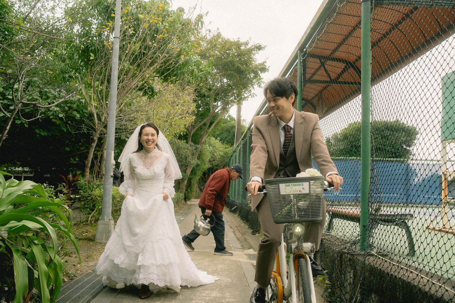 Playful Taipei pre-wedding photography of a bride and groom with a bicycle in a quiet neighborhood