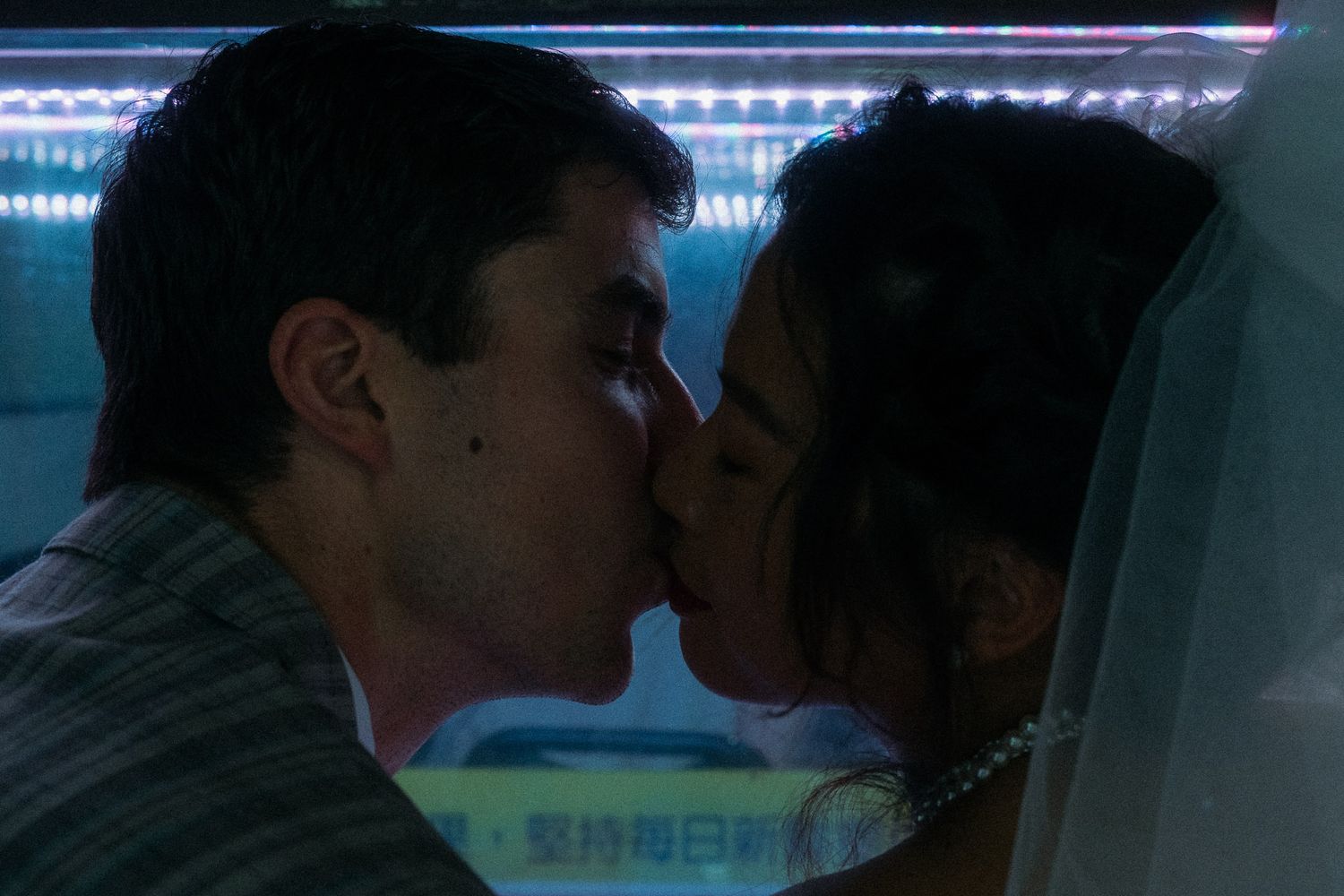 Emily and Nik kissing beneath blue aquarium light during a cinematic Taipei couple photoshoot